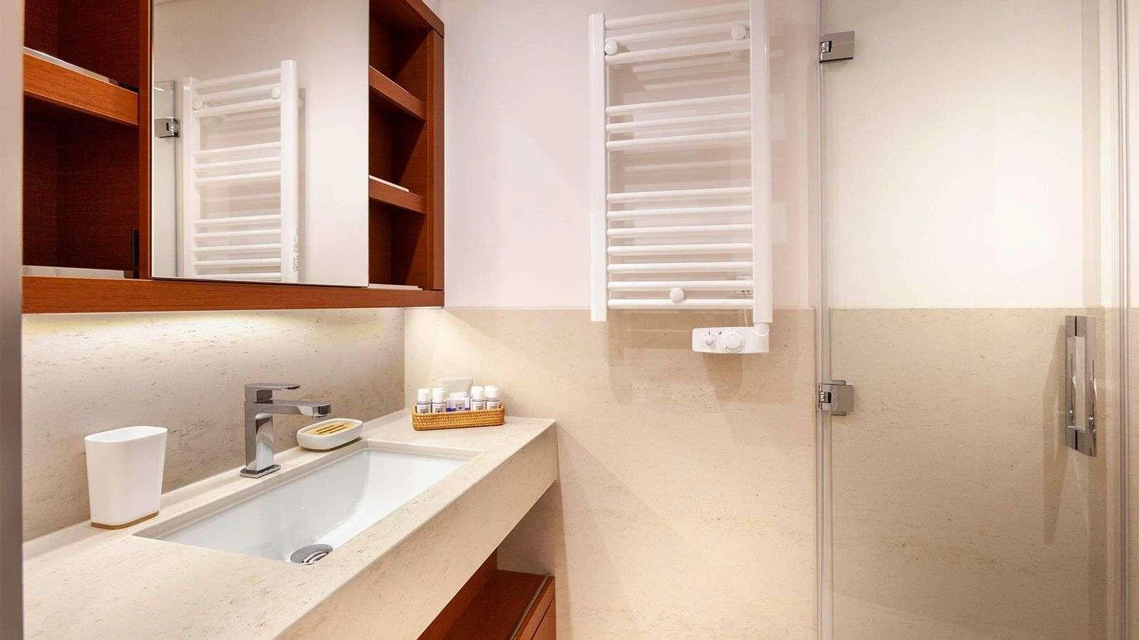 The bathroom features a sleek, modern design with a spacious sink and a glass-enclosed shower. aboard NEFESH Yacht for Charter