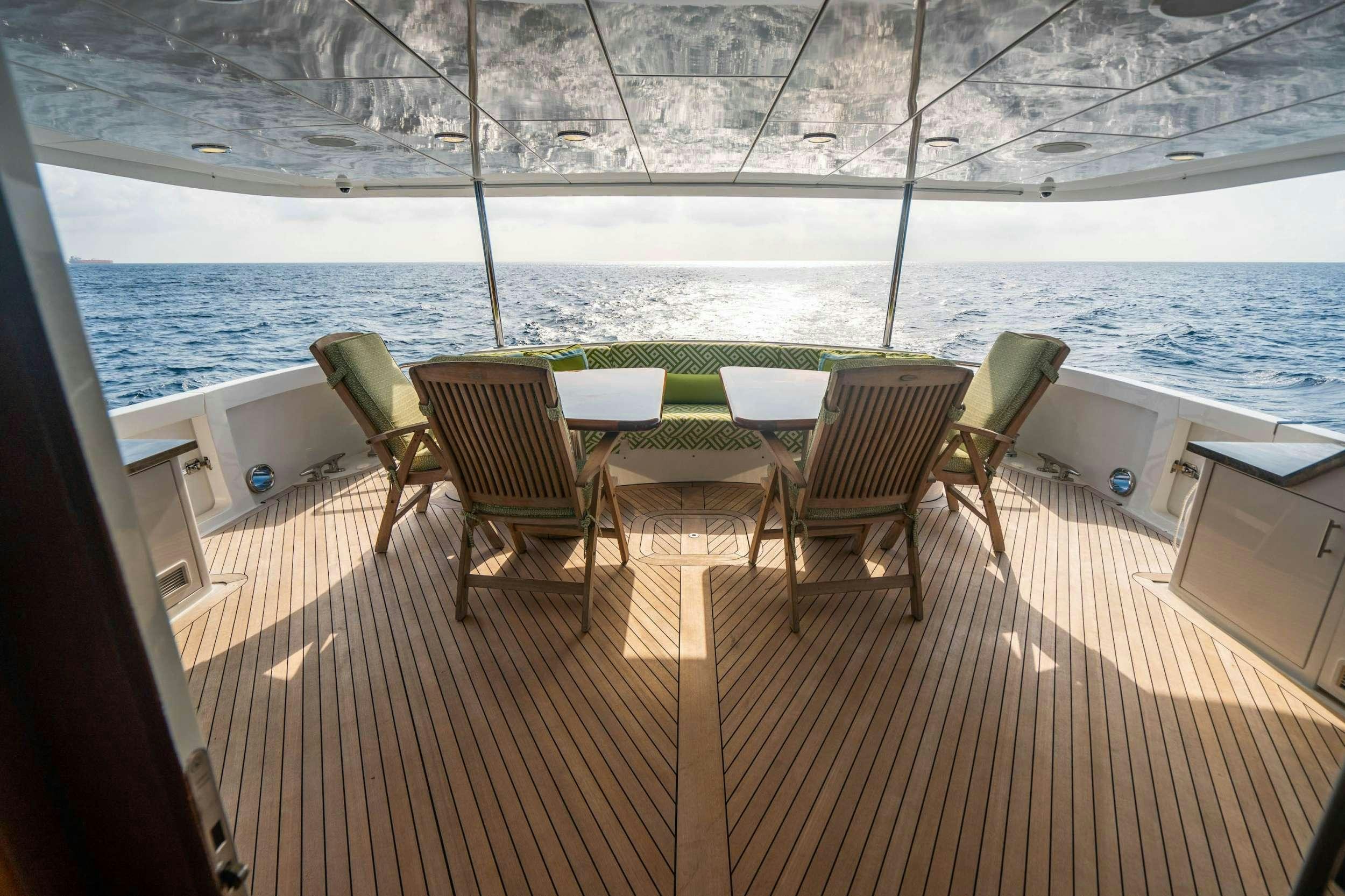 a deck with chairs and tables on it aboard INEVITABLE Yacht for Charter