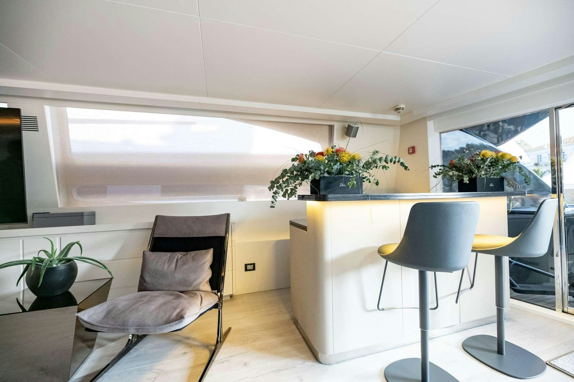 a room with a table chairs and plants aboard EVA Yacht for Charter