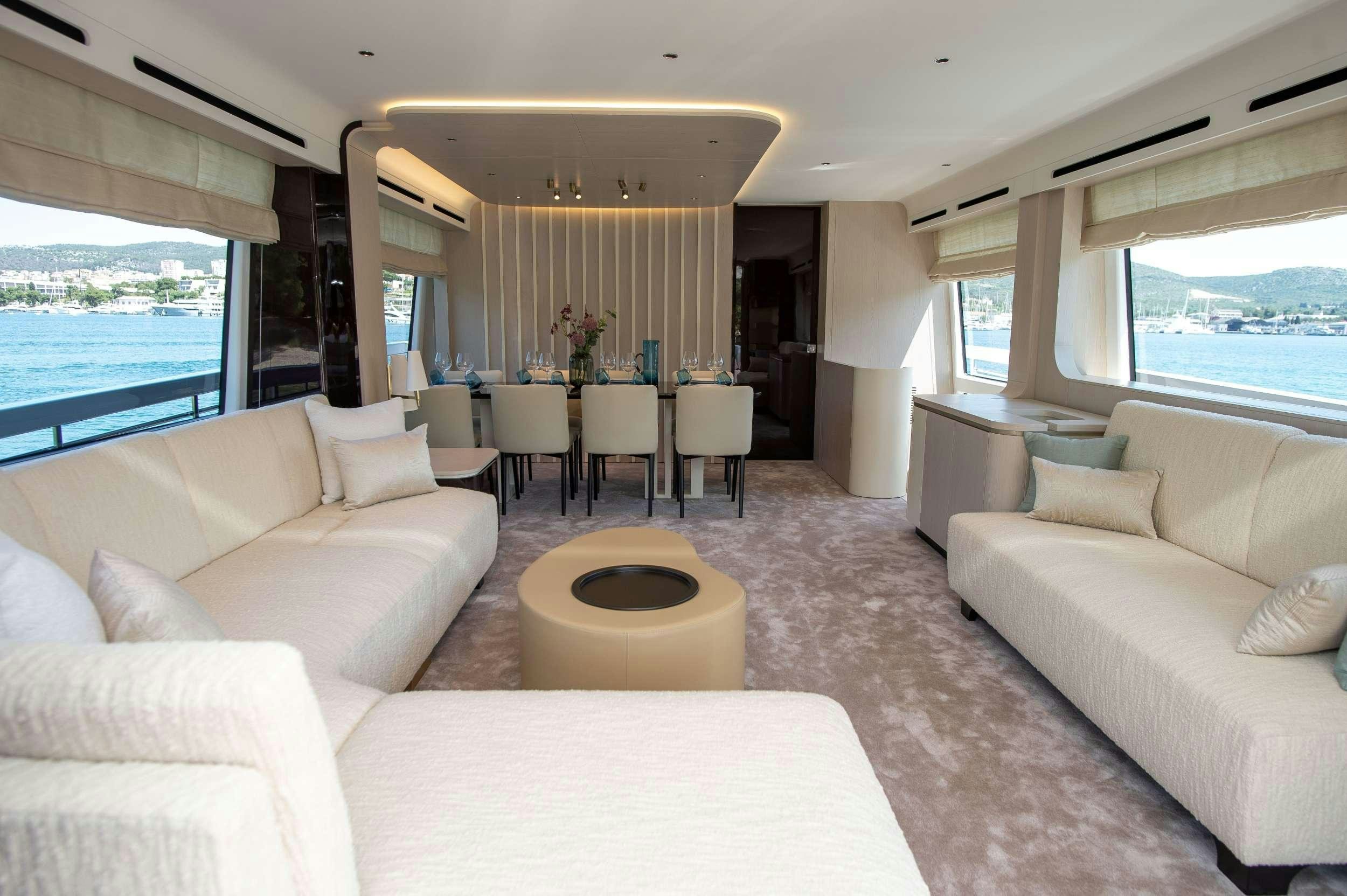 a living room with white couches and a table aboard PREWI Yacht for Charter