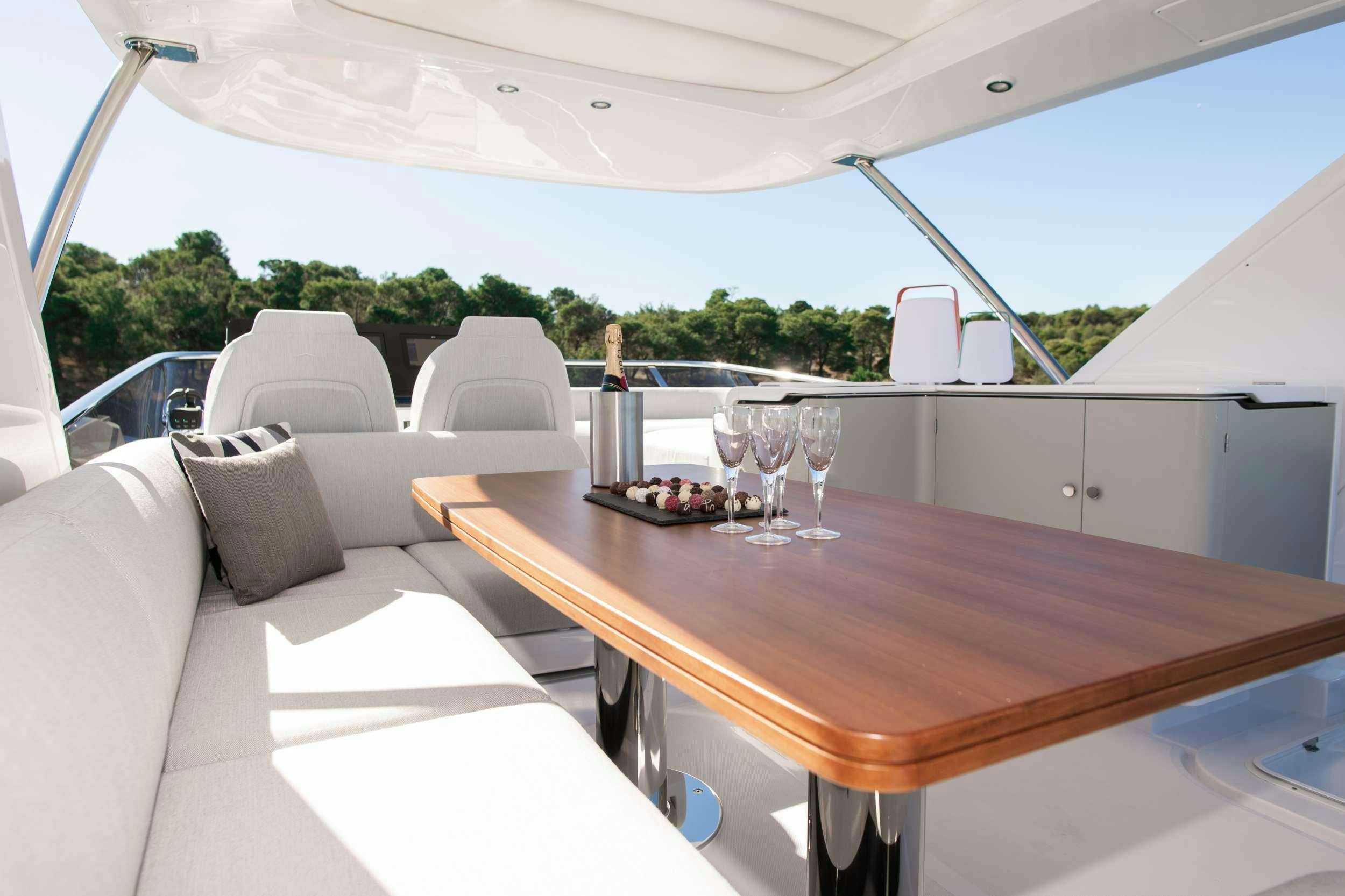 a table with chairs and a couch aboard ALIBABA Yacht for Charter