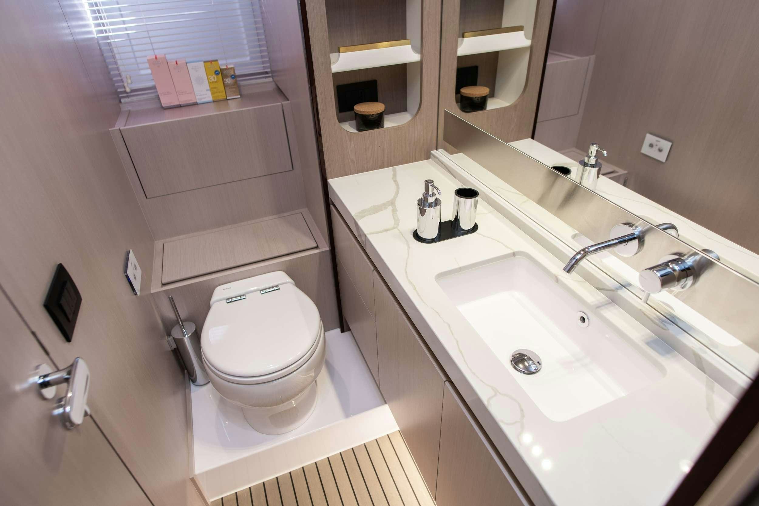 a bathroom with a toilet sink and a mirror aboard ALIBABA Yacht for Charter