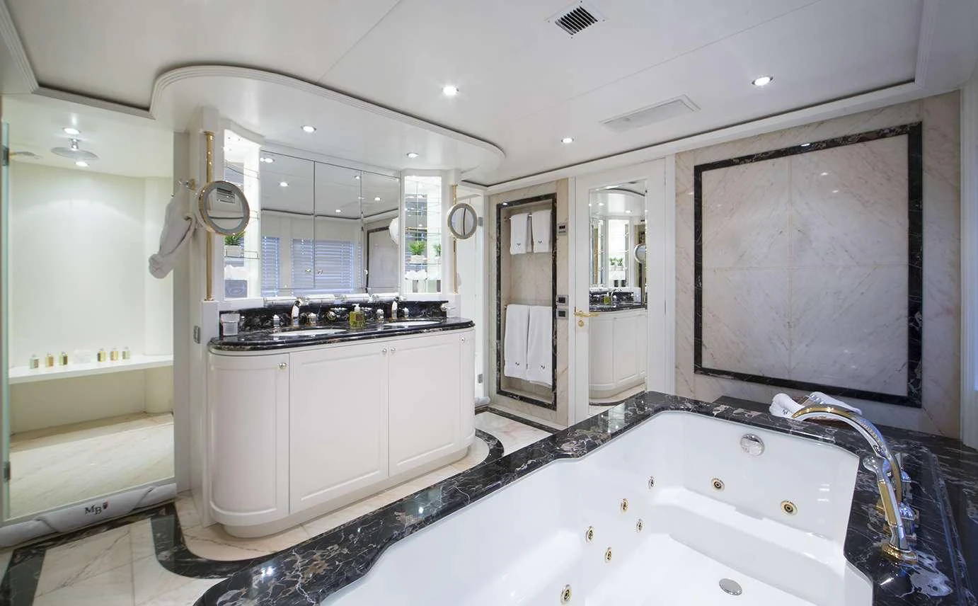 The luxurious bathroom features a spacious jacuzzi tub and elegant marble accents. aboard MAC BREW Yacht for Charter