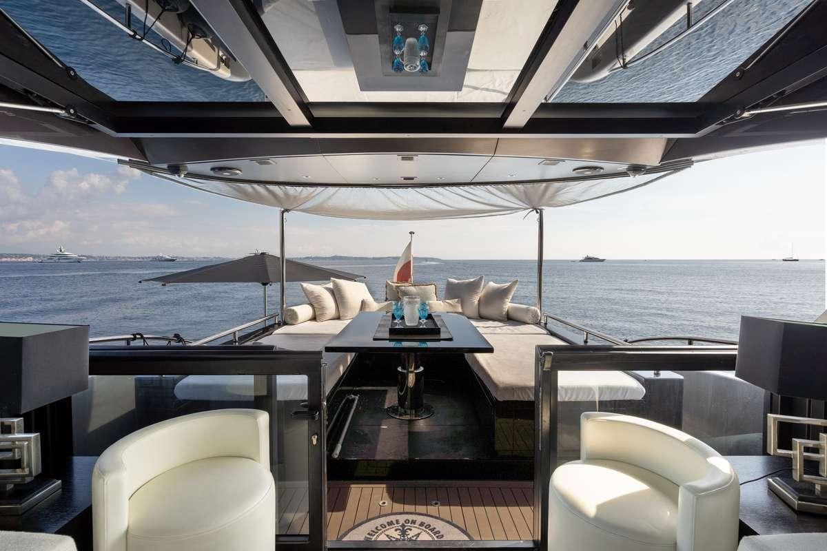 a large lounge area with a table and chairs and a large body of water aboard TOMMY I Yacht for Charter