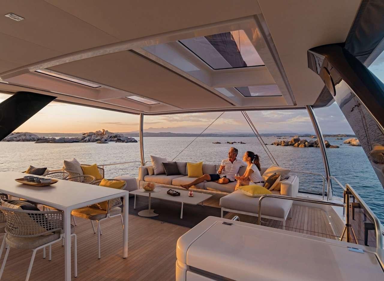 a couple sitting on a couch aboard AEOLUS 77 Yacht for Charter