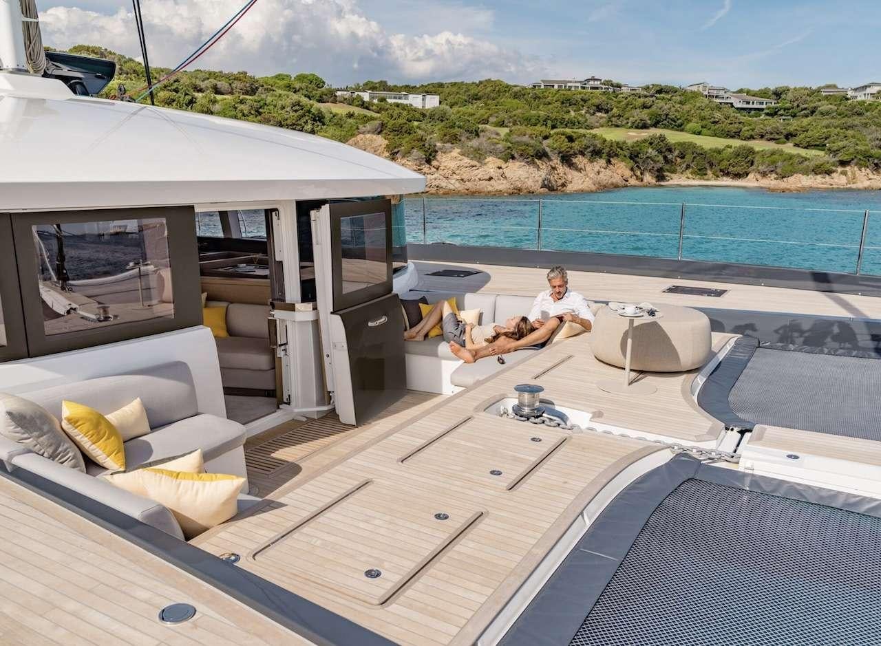 a person sitting on a lounge chair on a deck next to a pool aboard AEOLUS 77 Yacht for Charter