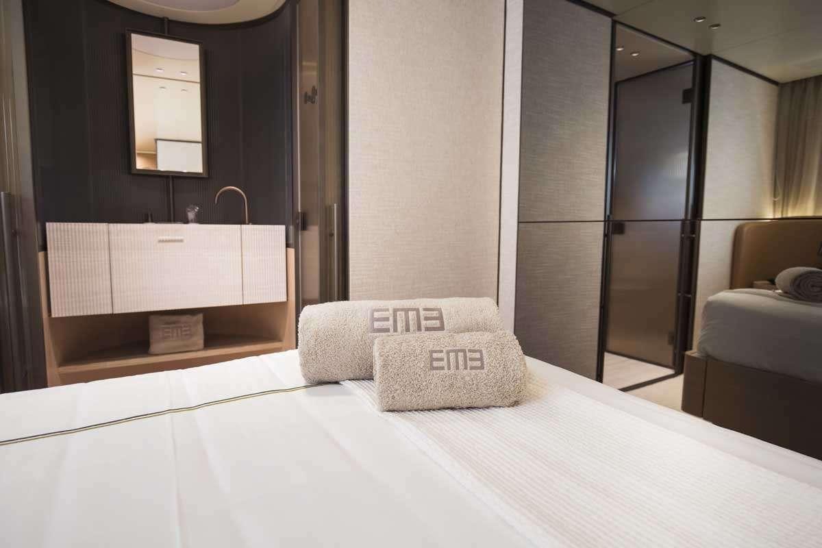 a bed with a white pillow aboard EM3 Yacht for Charter