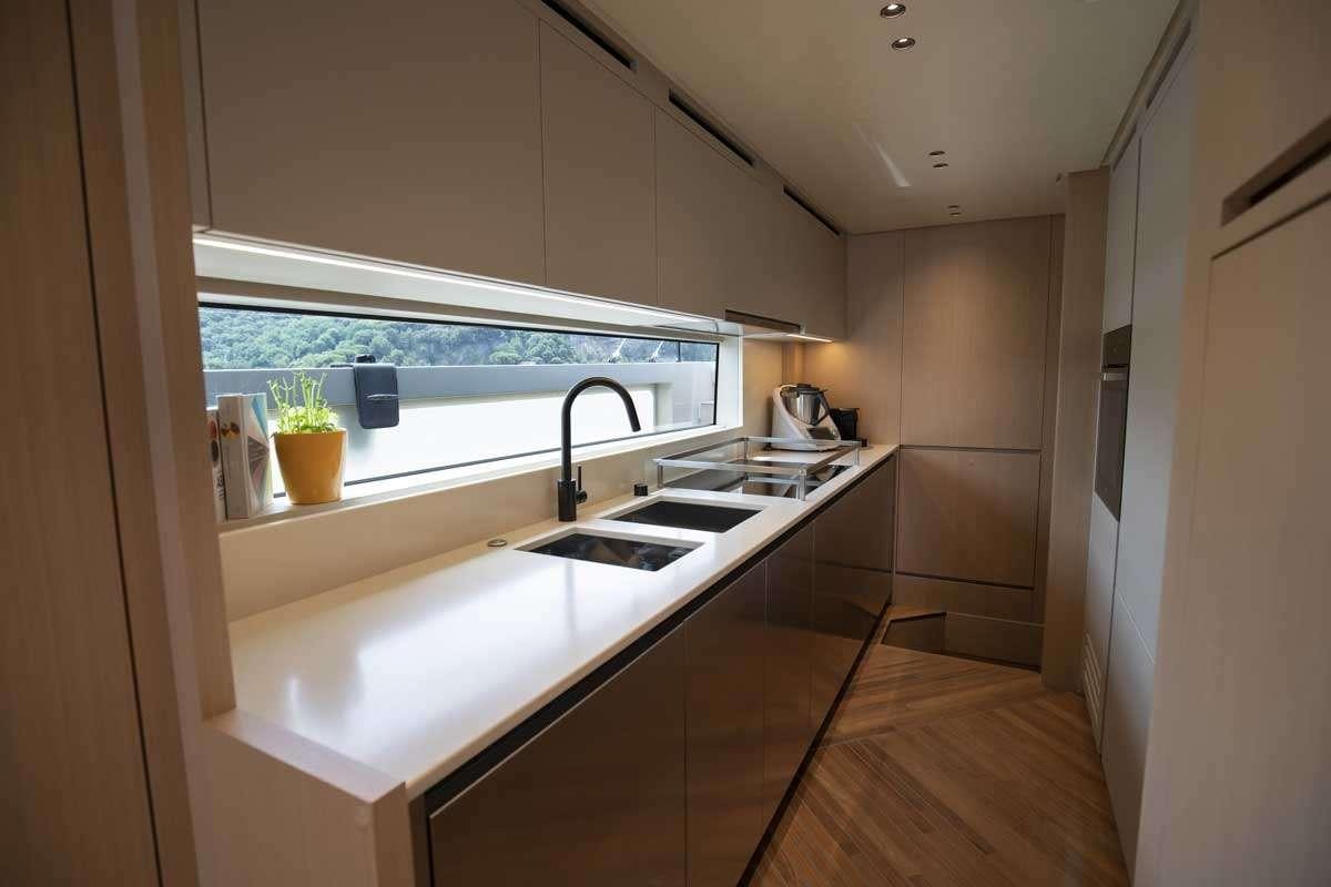 a kitchen with a sink and a window aboard EM3 Yacht for Charter