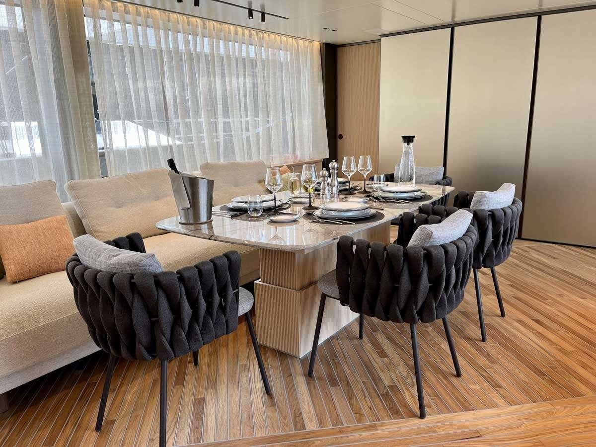 a dining table set with chairs aboard EM3 Yacht for Charter