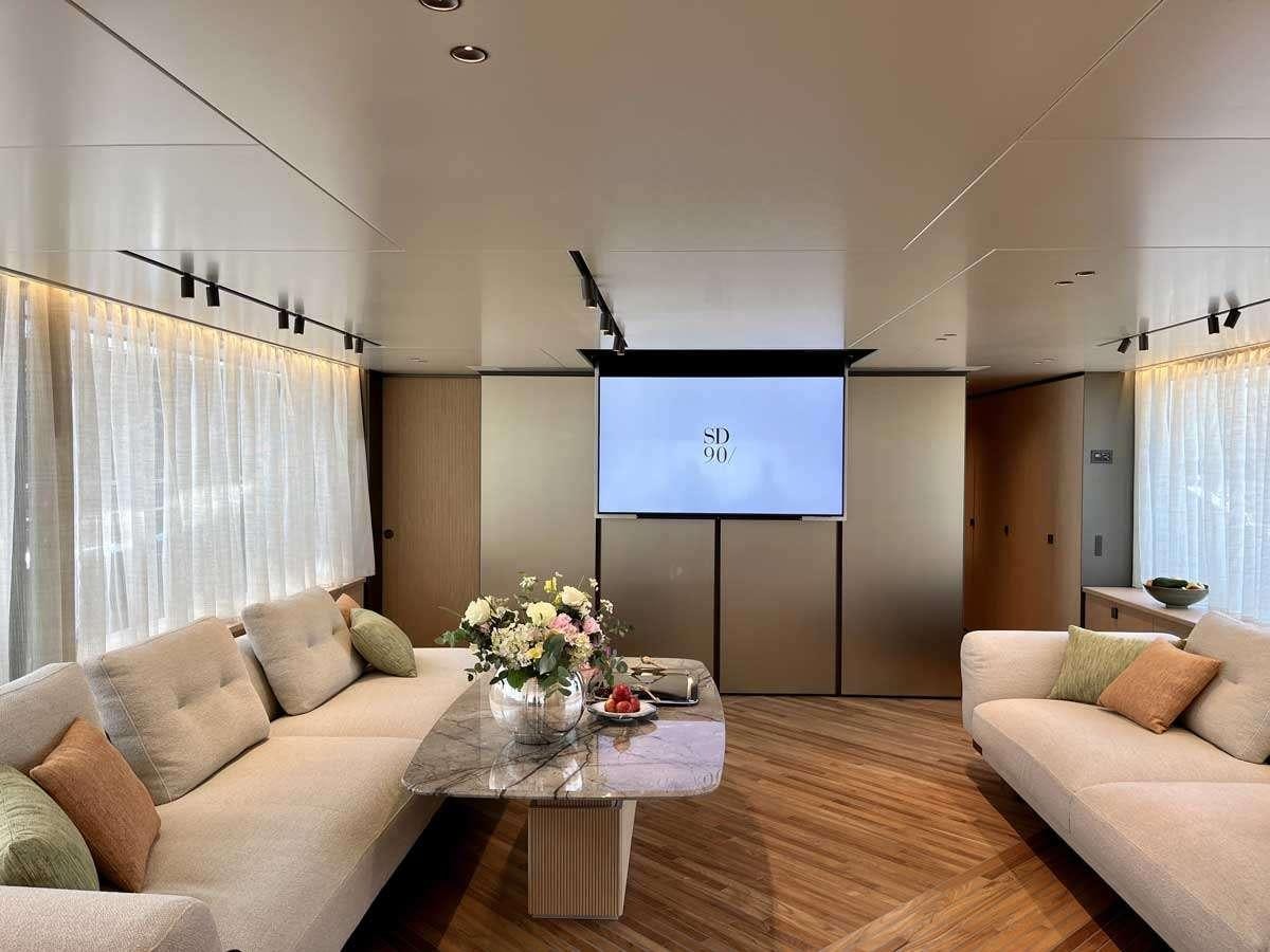 a living room with a large screen aboard EM3 Yacht for Charter