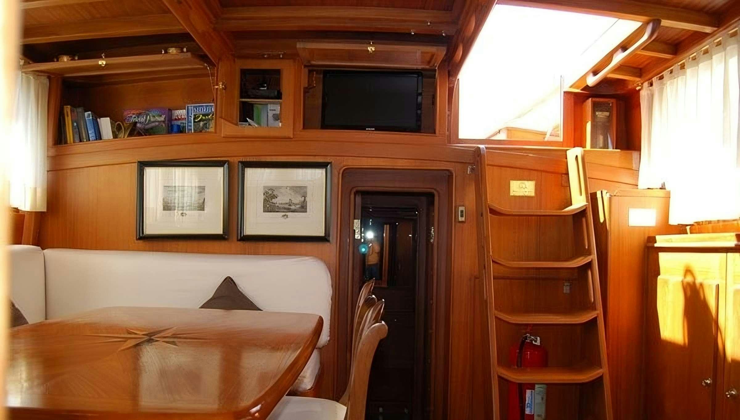 a room with a table and a television aboard PAULENA Yacht for Charter