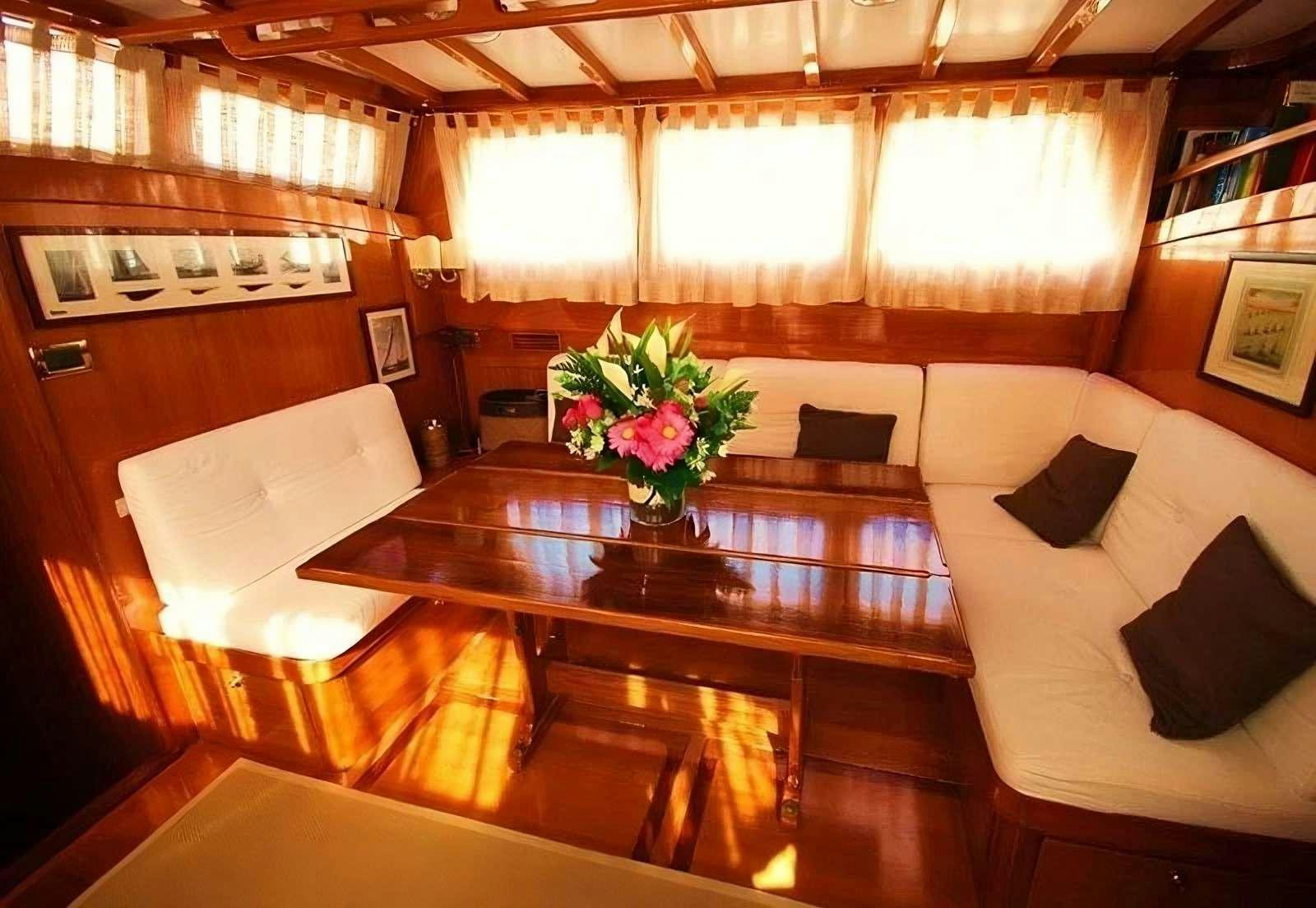 a room with a table and couches aboard PAULENA Yacht for Charter