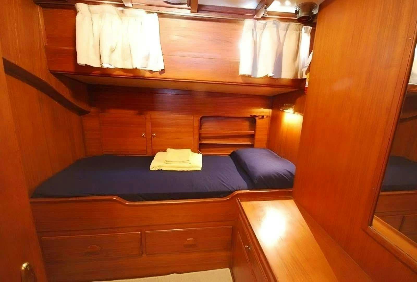 a bed with white sheets aboard PAULENA Yacht for Charter