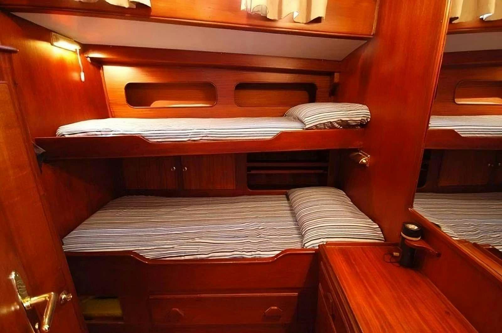 a bed with a wood frame aboard PAULENA Yacht for Charter