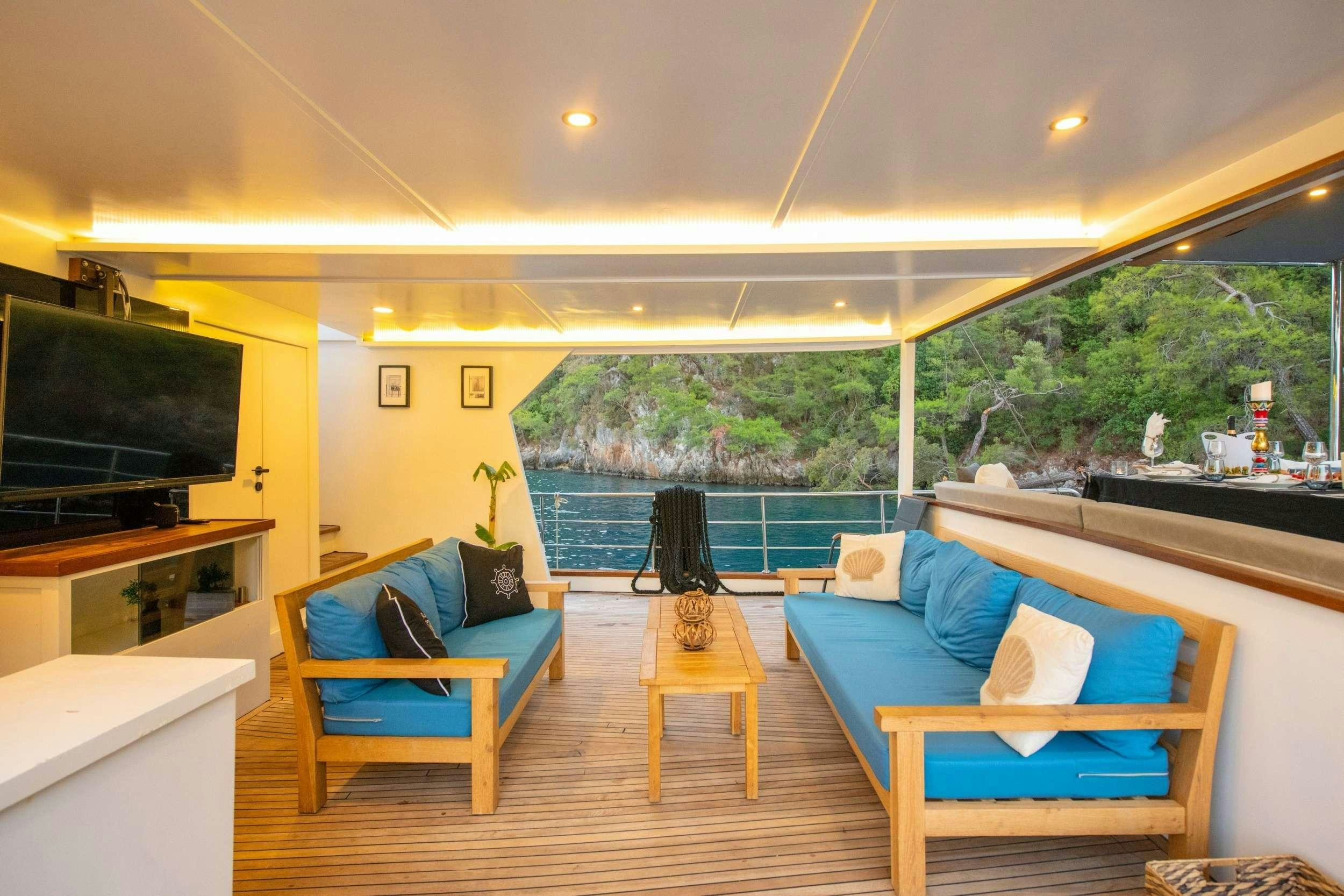a living room with a blue couch and a tv aboard NAYK 2 Yacht for Charter