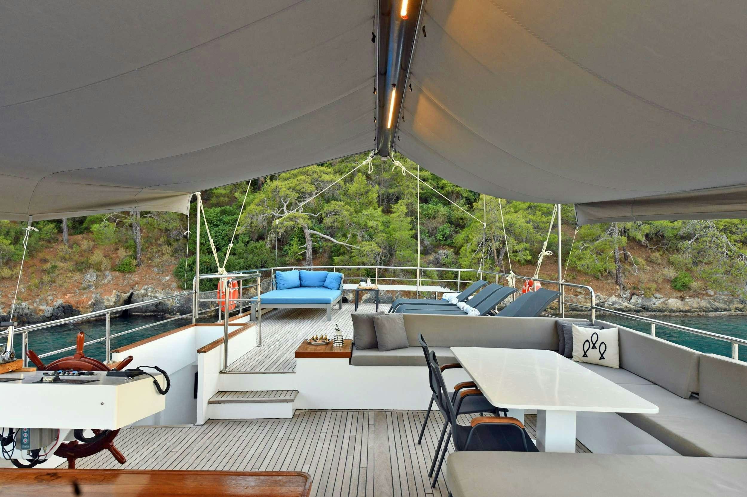 a tent with a pool and a deck with a view of trees aboard NAYK 2 Yacht for Charter