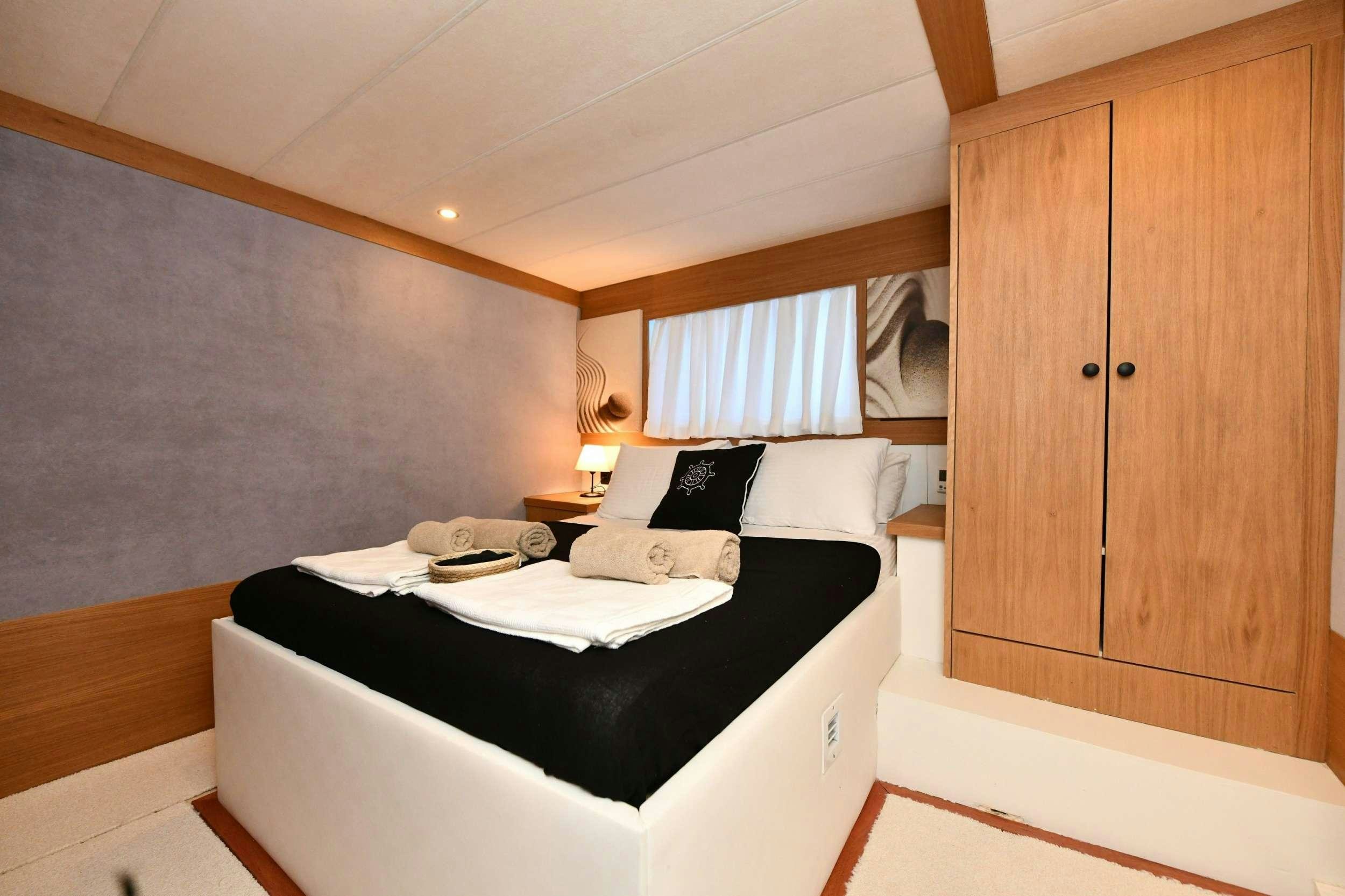 a bedroom with a bed and cabinets aboard NAYK 2 Yacht for Charter