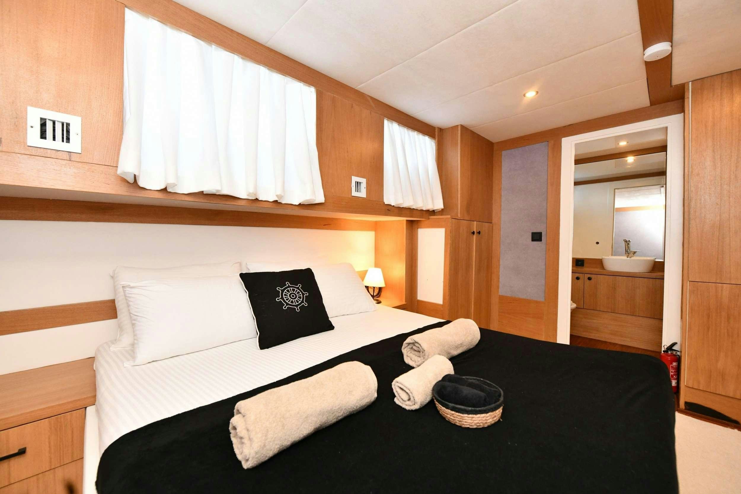 a bed with white sheets and pillows aboard NAYK 2 Yacht for Charter