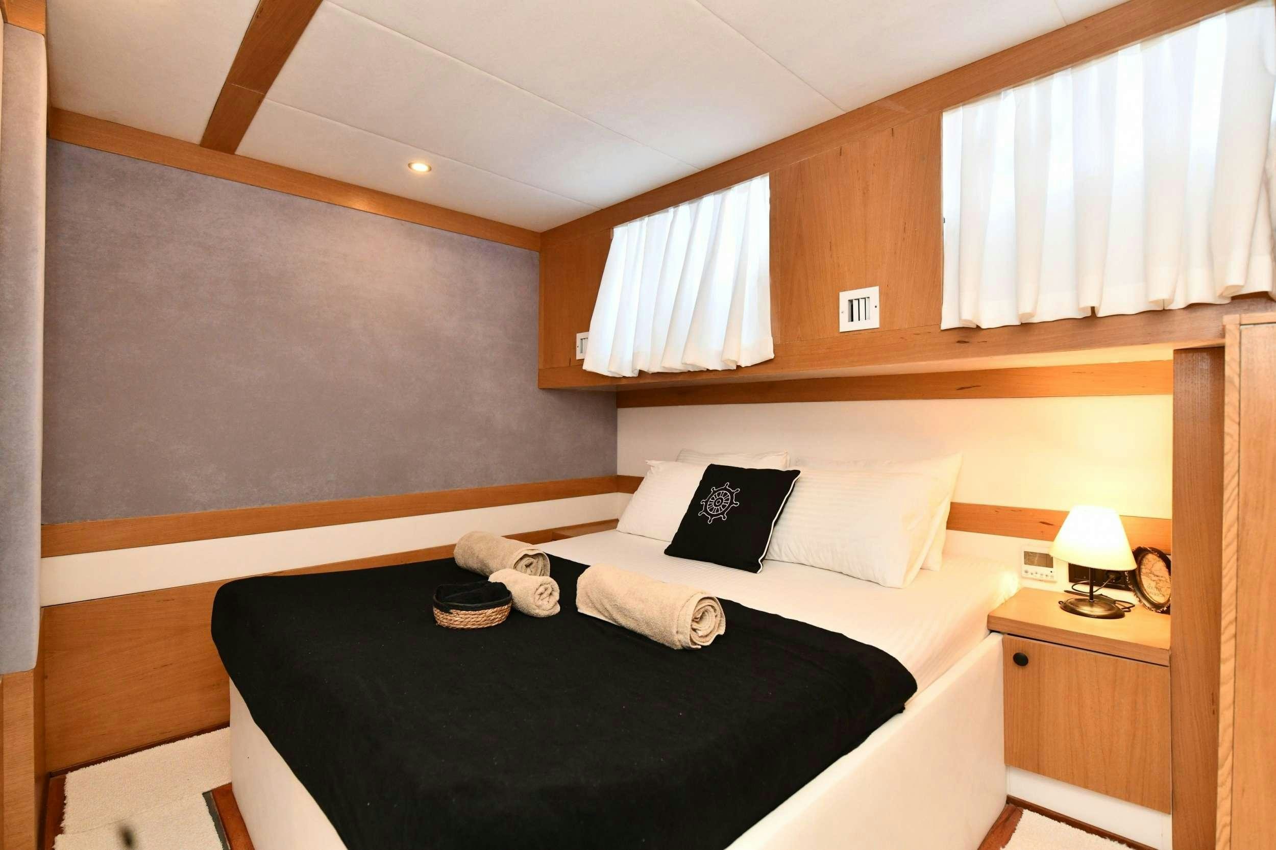 a bed with a black and white pillow and pillows aboard NAYK 2 Yacht for Charter