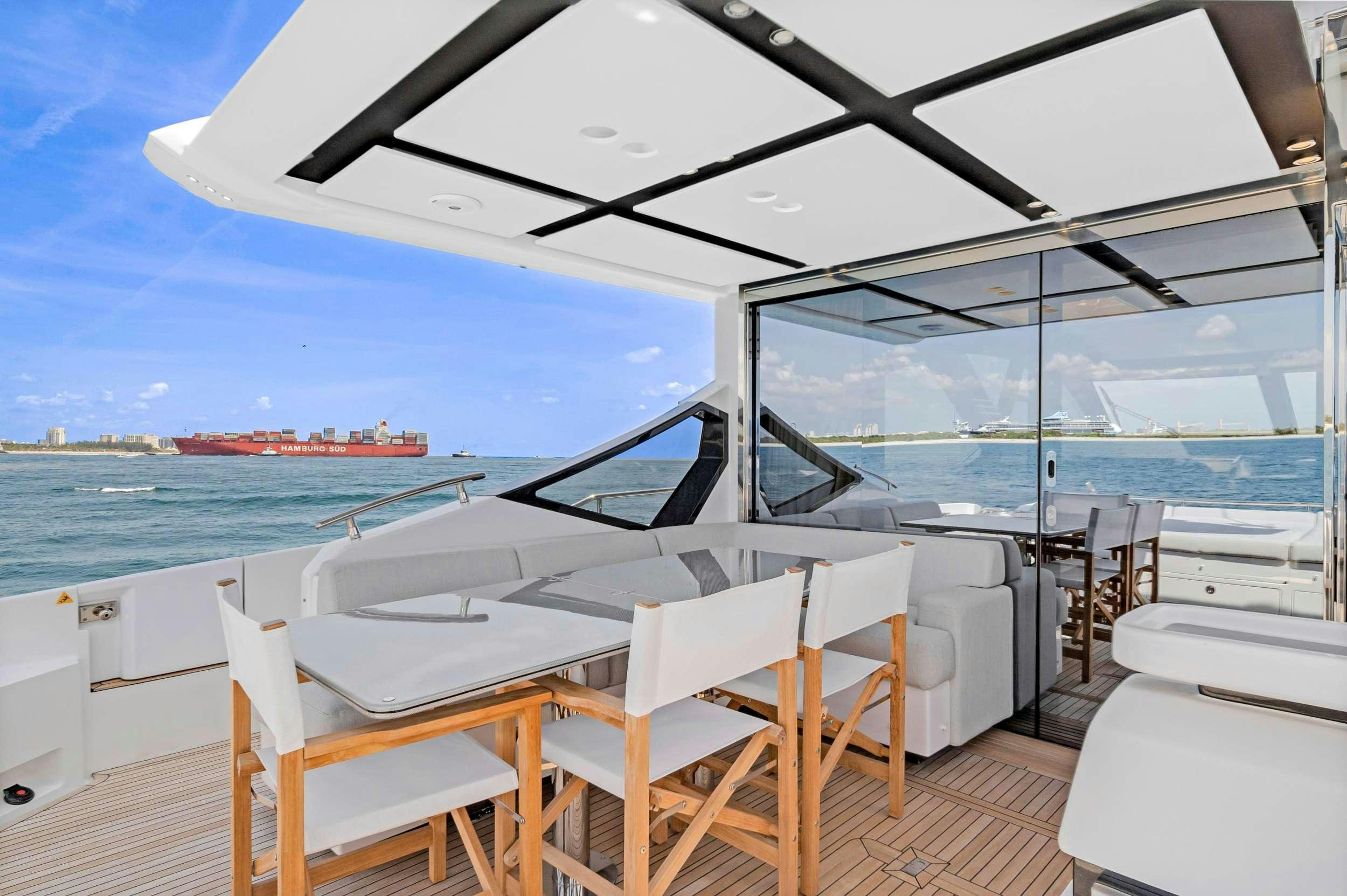 a room with a table and chairs on a deck overlooking the ocean aboard ANOTHER CHANCE II Yacht for Charter
