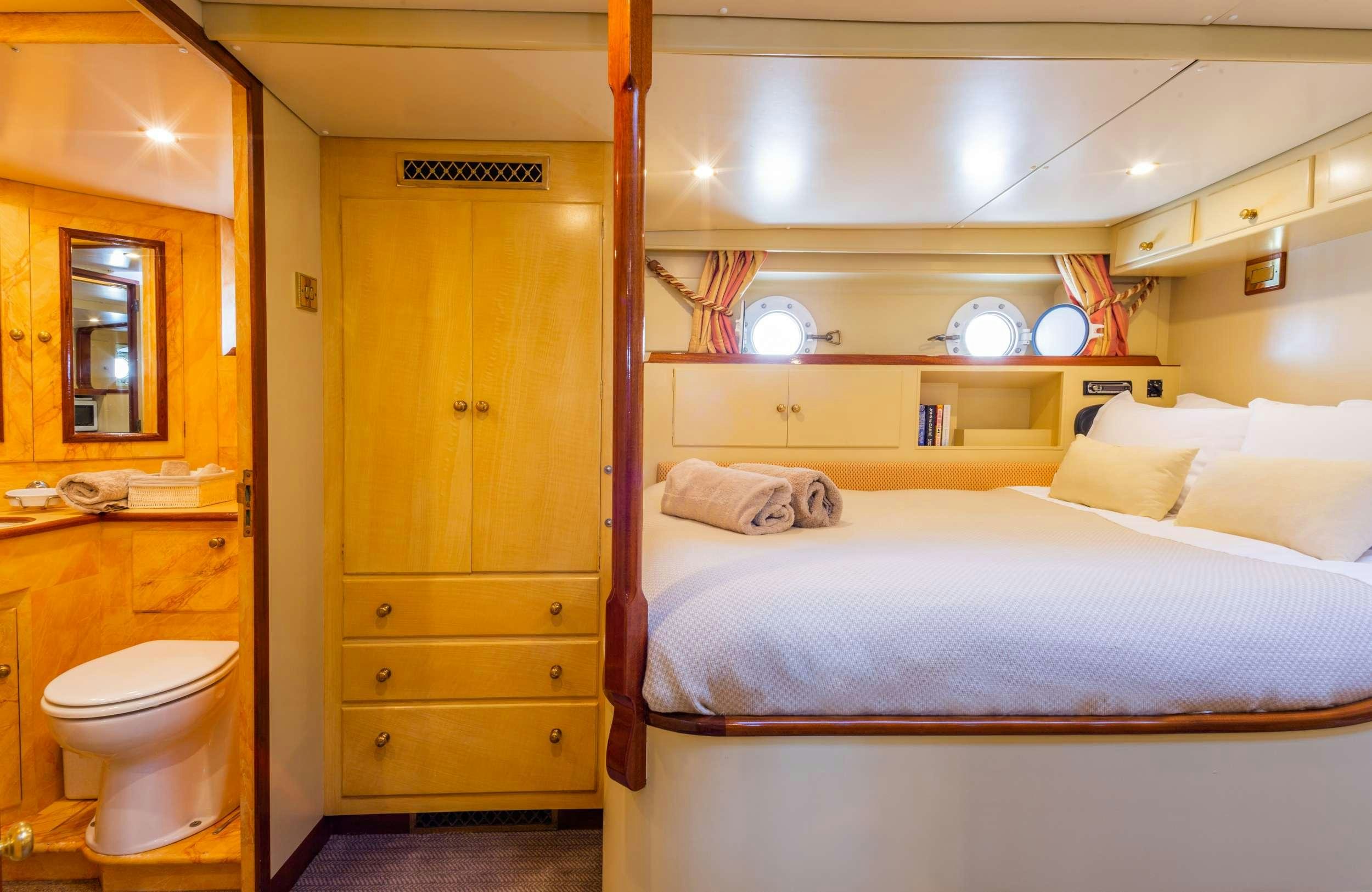a bedroom with a bed and a closet aboard WINDWEAVER OF PENNINGTON Yacht for Charter
