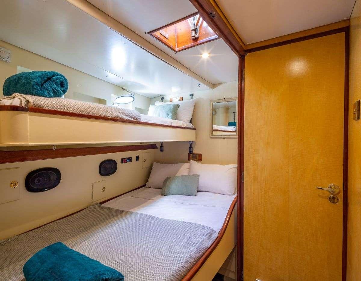 a room with a bed and a mirror aboard WINDWEAVER OF PENNINGTON Yacht for Charter