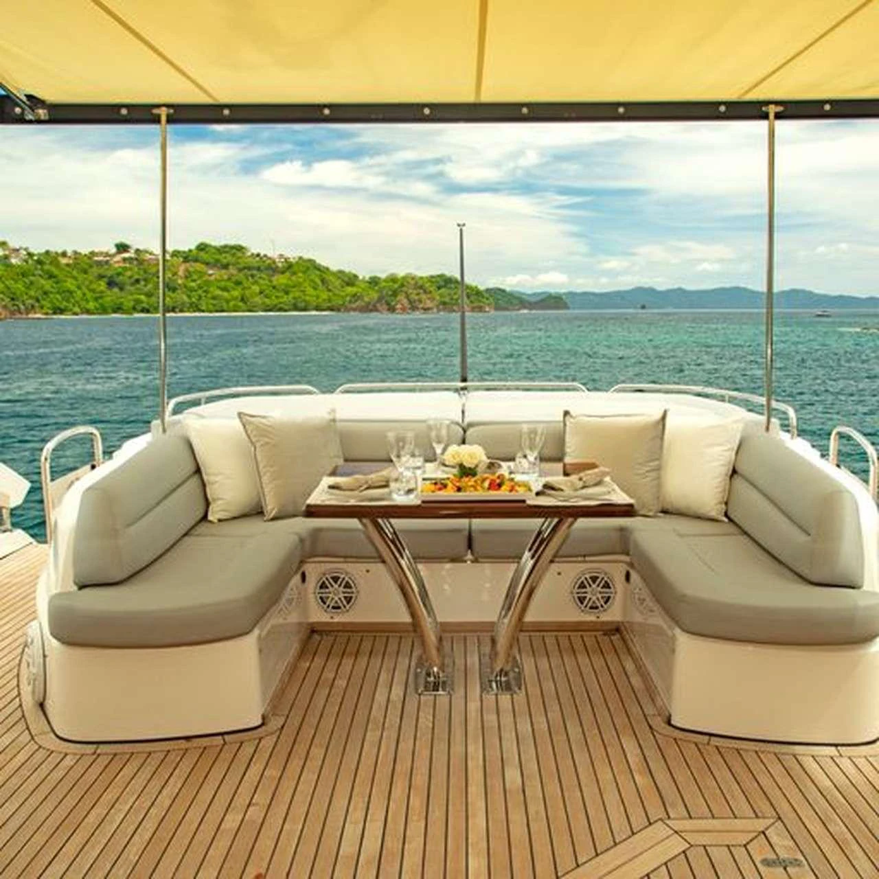 a table and chairs on a deck overlooking a body of water aboard COSTASOL Yacht for Charter