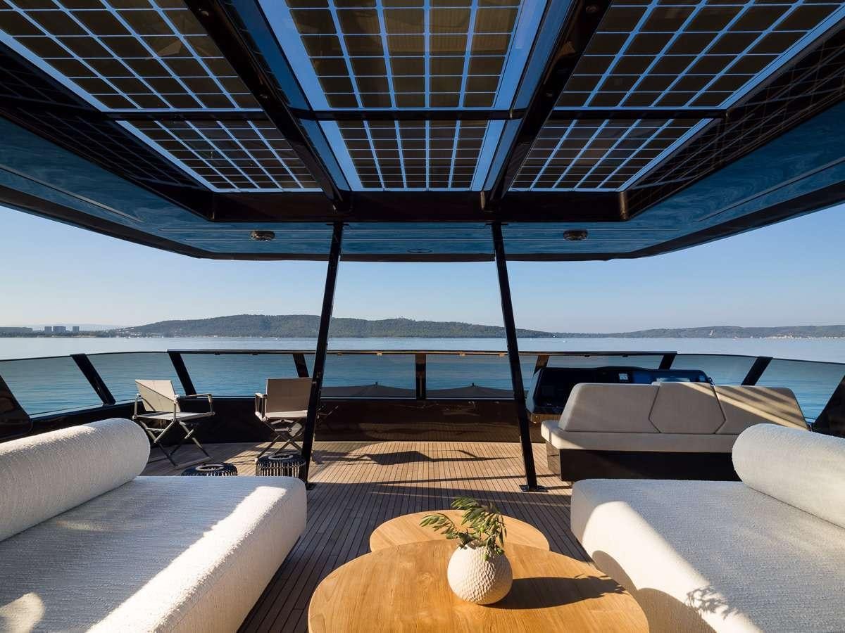 a lounge area with a large deck overlooking the ocean aboard AMBER ONE Yacht for Charter