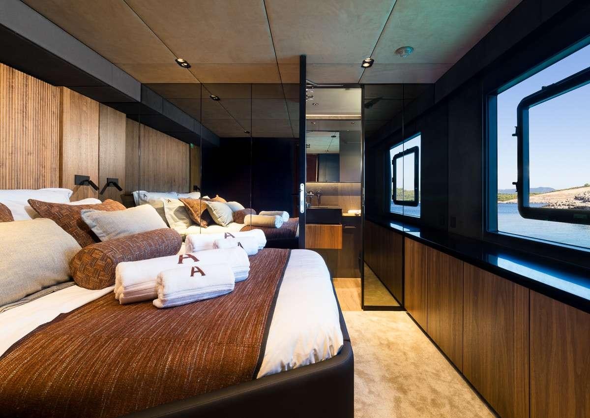 a room with a bed and a large window aboard AMBER ONE Yacht for Charter