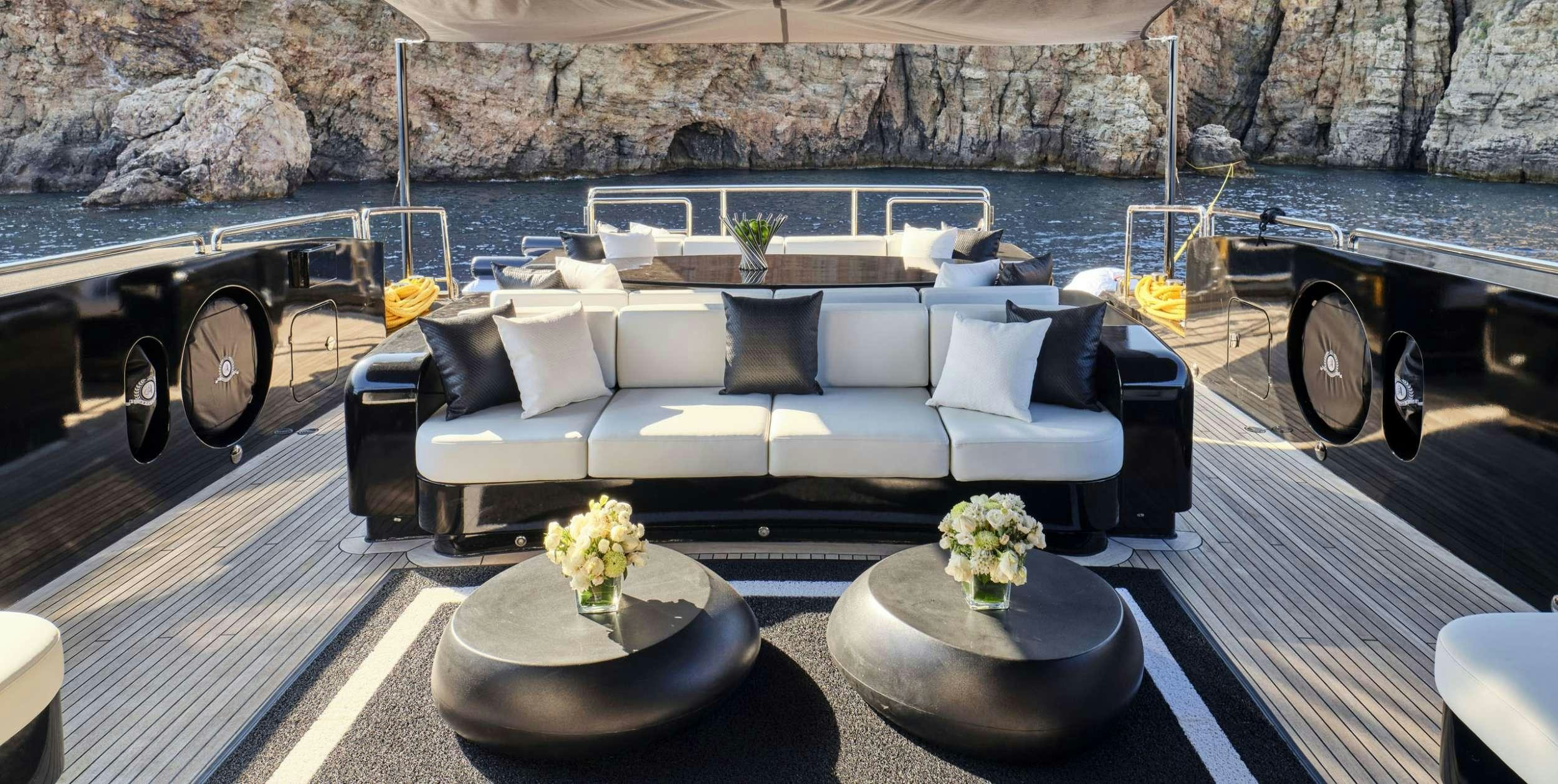 a large white couch with a round table in front of it aboard ABILITY Yacht for Charter