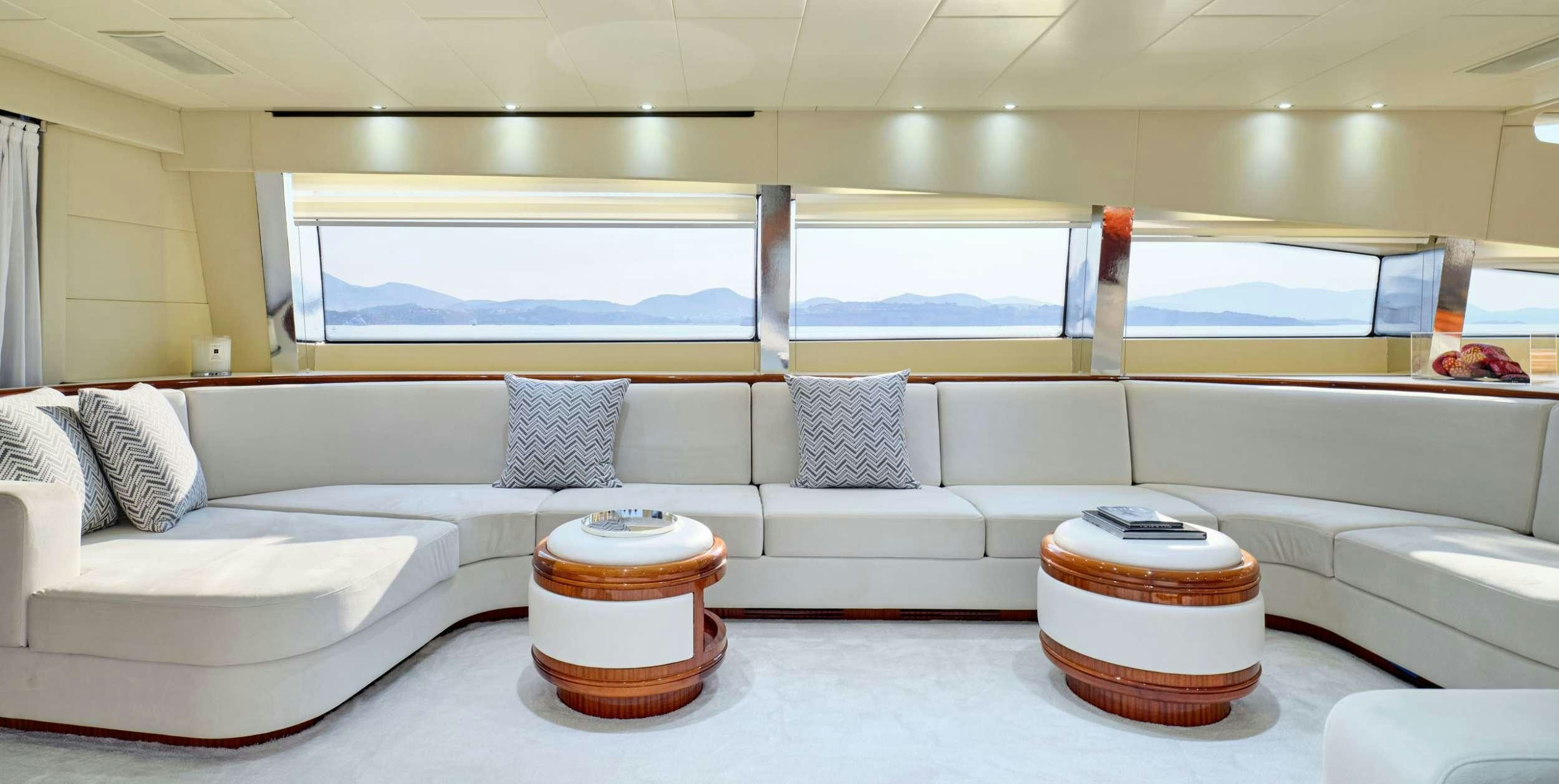 a room with a couch and a table with a window aboard ABILITY Yacht for Charter