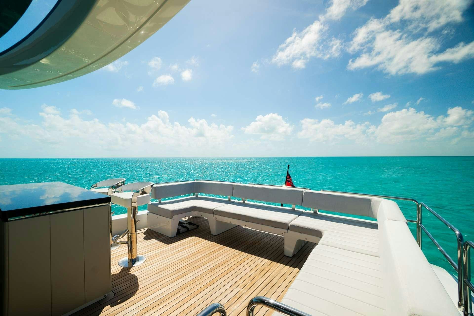 a deck with a view of the ocean and a beach aboard NORMAN'S T4 Yacht for Charter