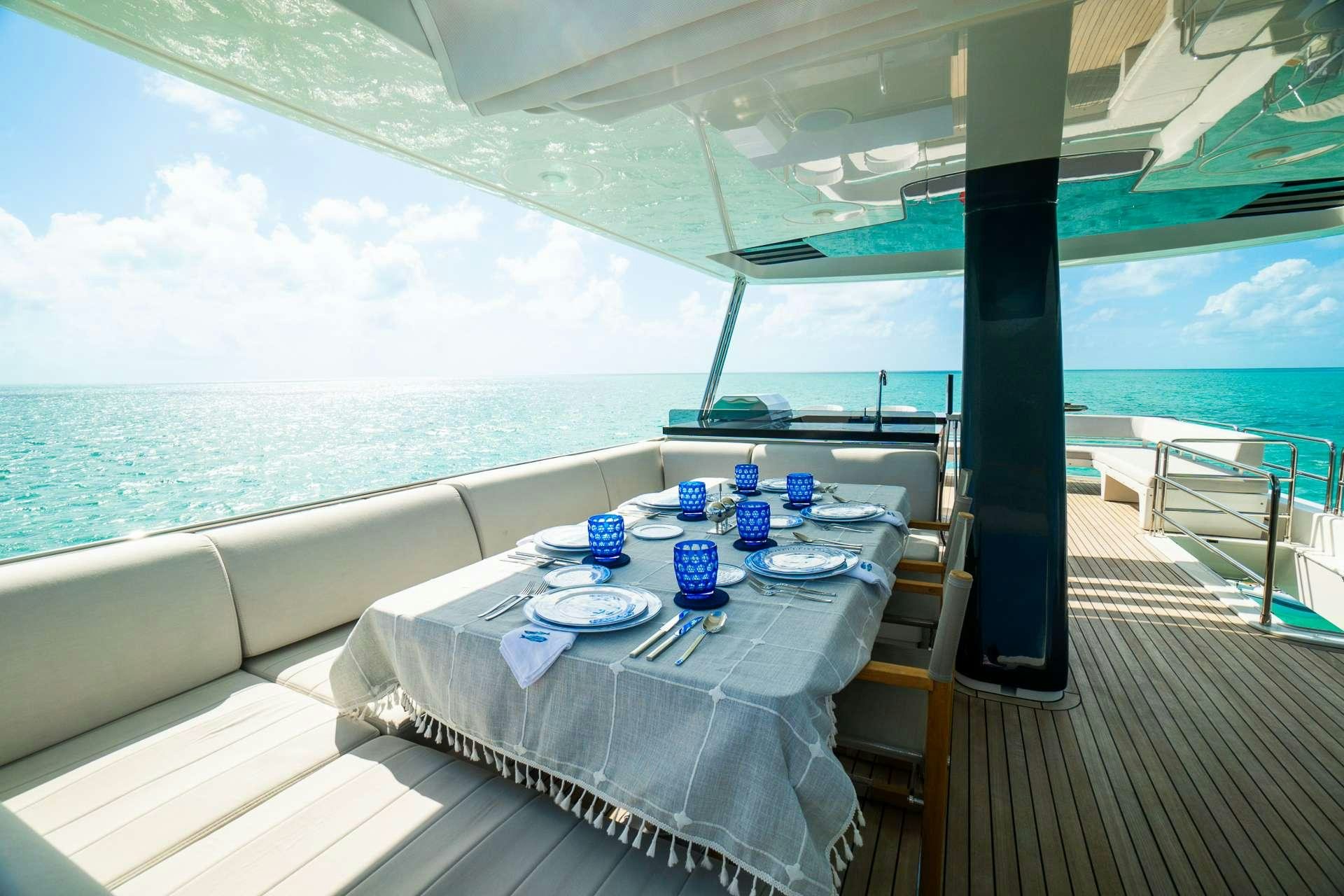 a table set for a meal on a balcony overlooking the ocean aboard NORMAN'S T4 Yacht for Charter