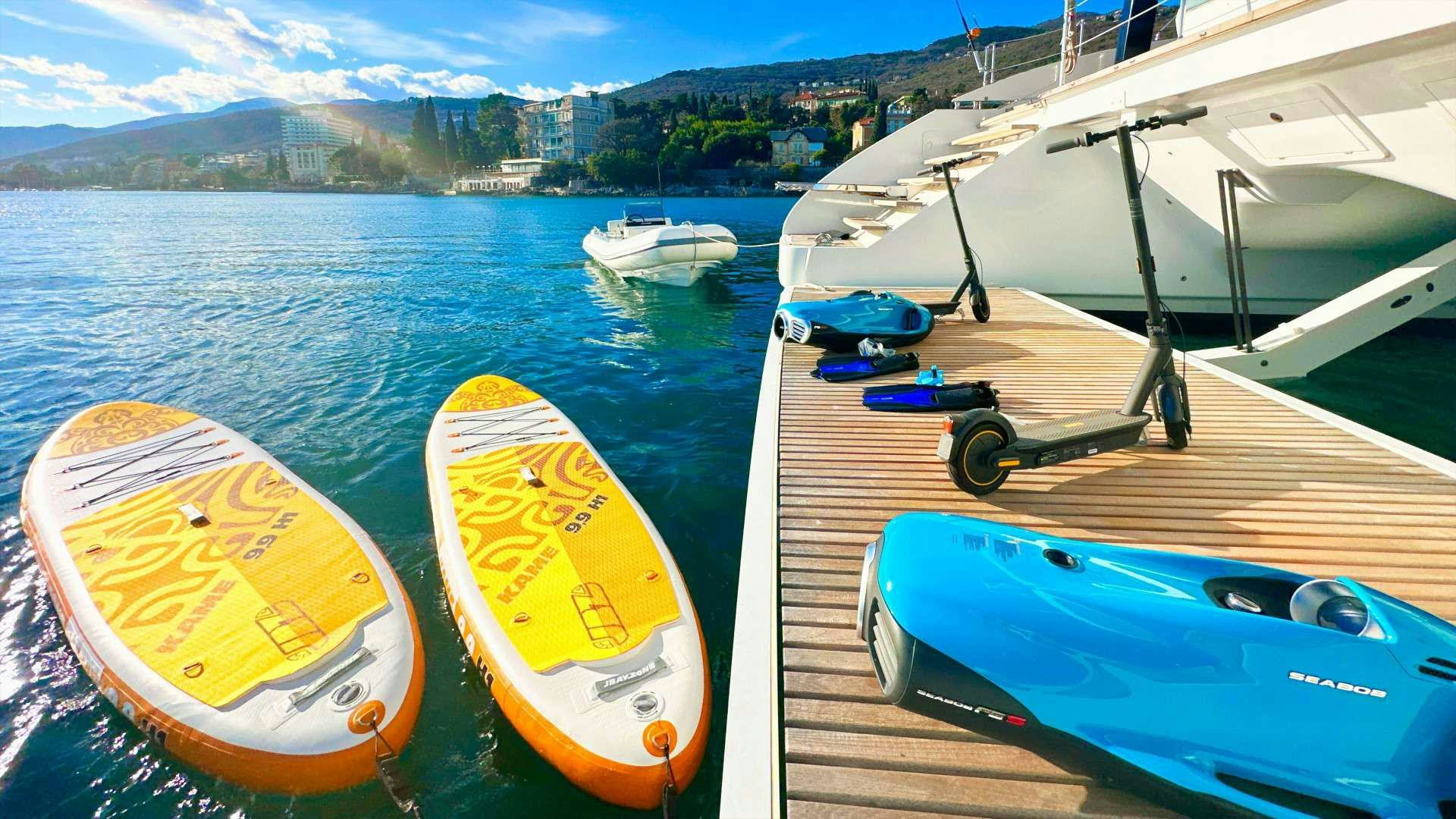 a yellow and blue kayak on a deck next to a boat aboard NALA ONE Yacht for Charter