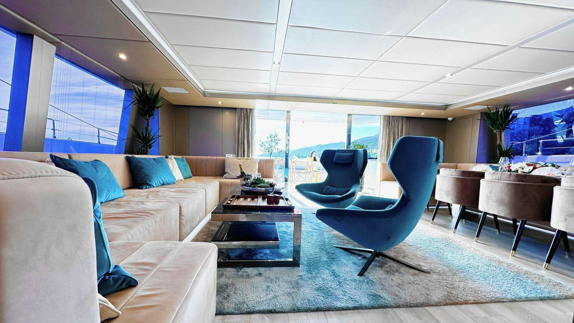 a living room with a blue couch aboard NALA ONE Yacht for Charter