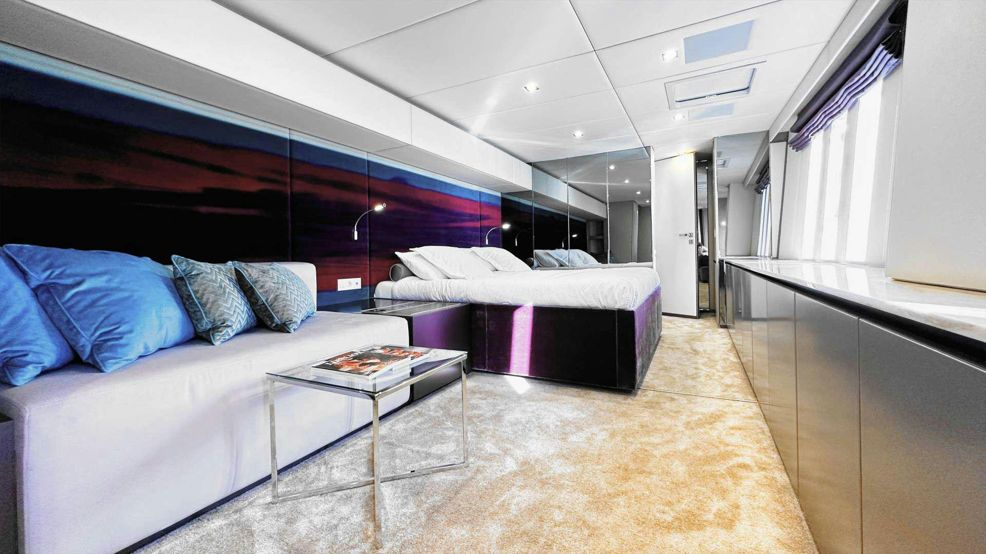 a room with a bed and a table aboard NALA ONE Yacht for Charter