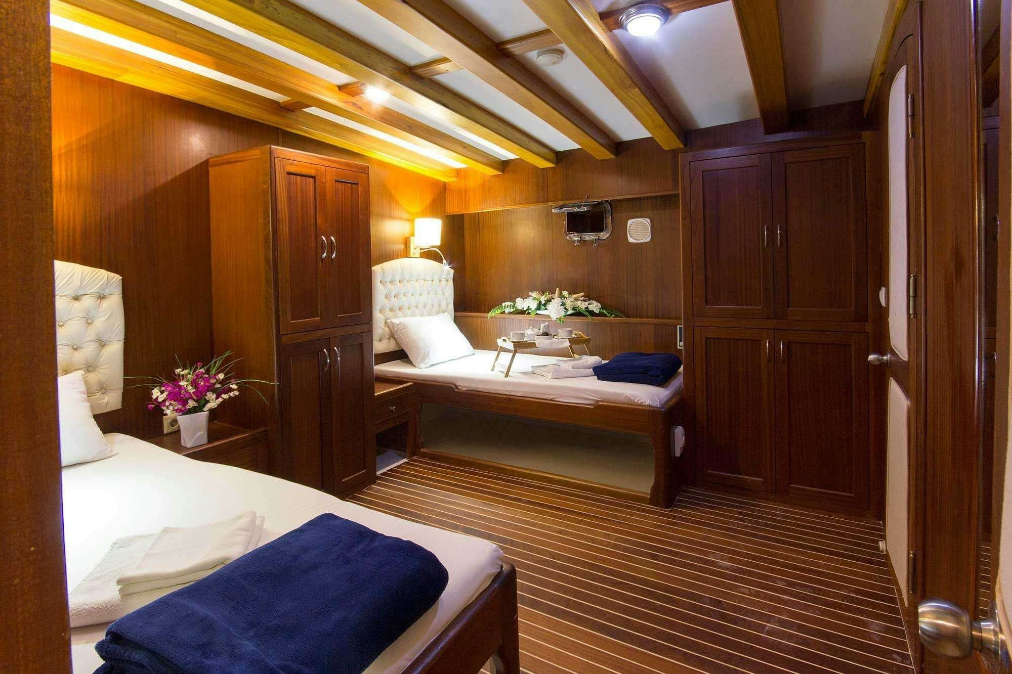 a room with a bed and a table aboard BOREAS Yacht for Charter