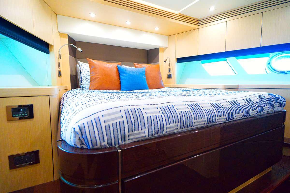 a bed with a blue and white striped pillow aboard DADDY'S $ Yacht for Charter