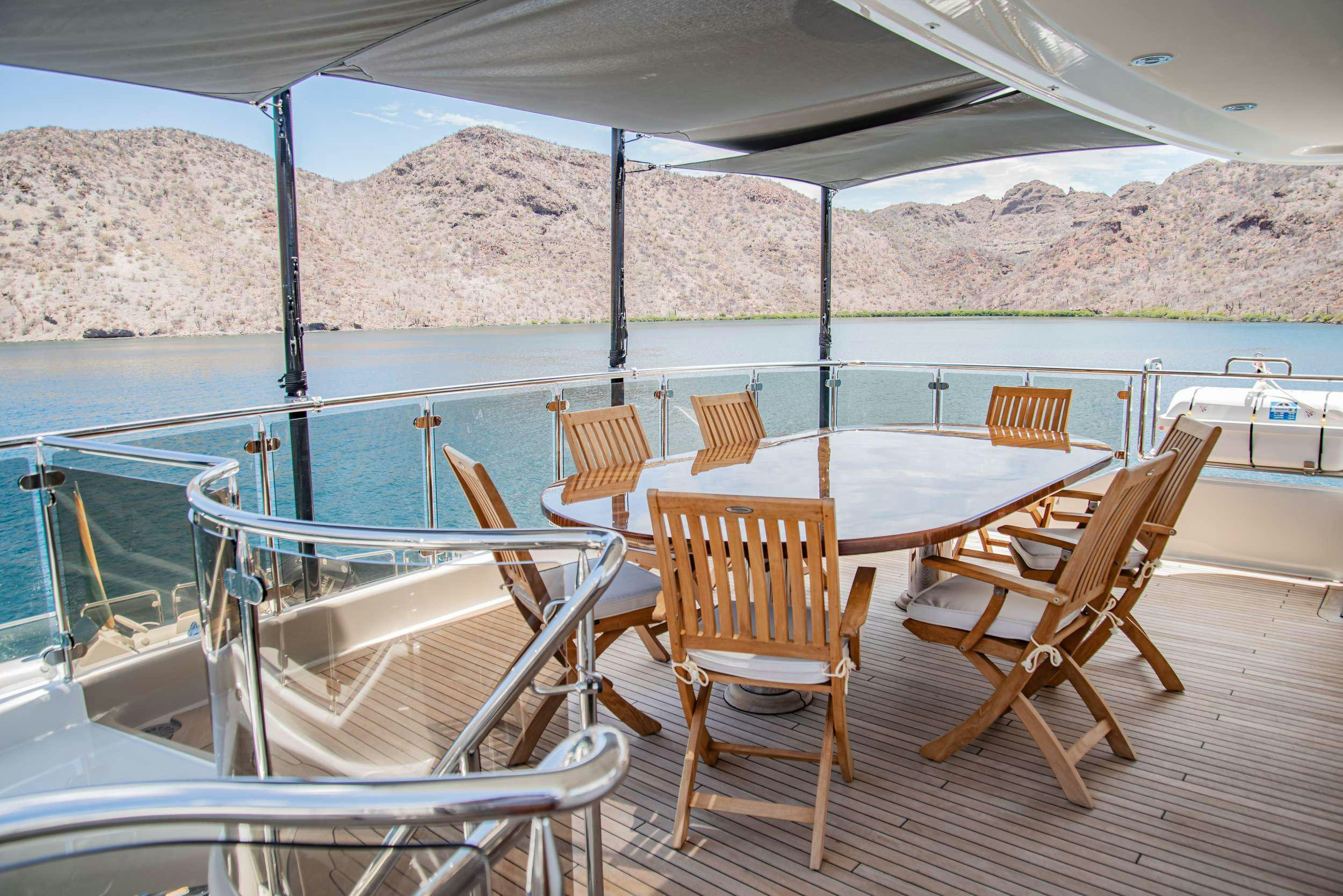 a group of chairs on a deck overlooking a body of water aboard RULE NO. 1 Yacht for Charter