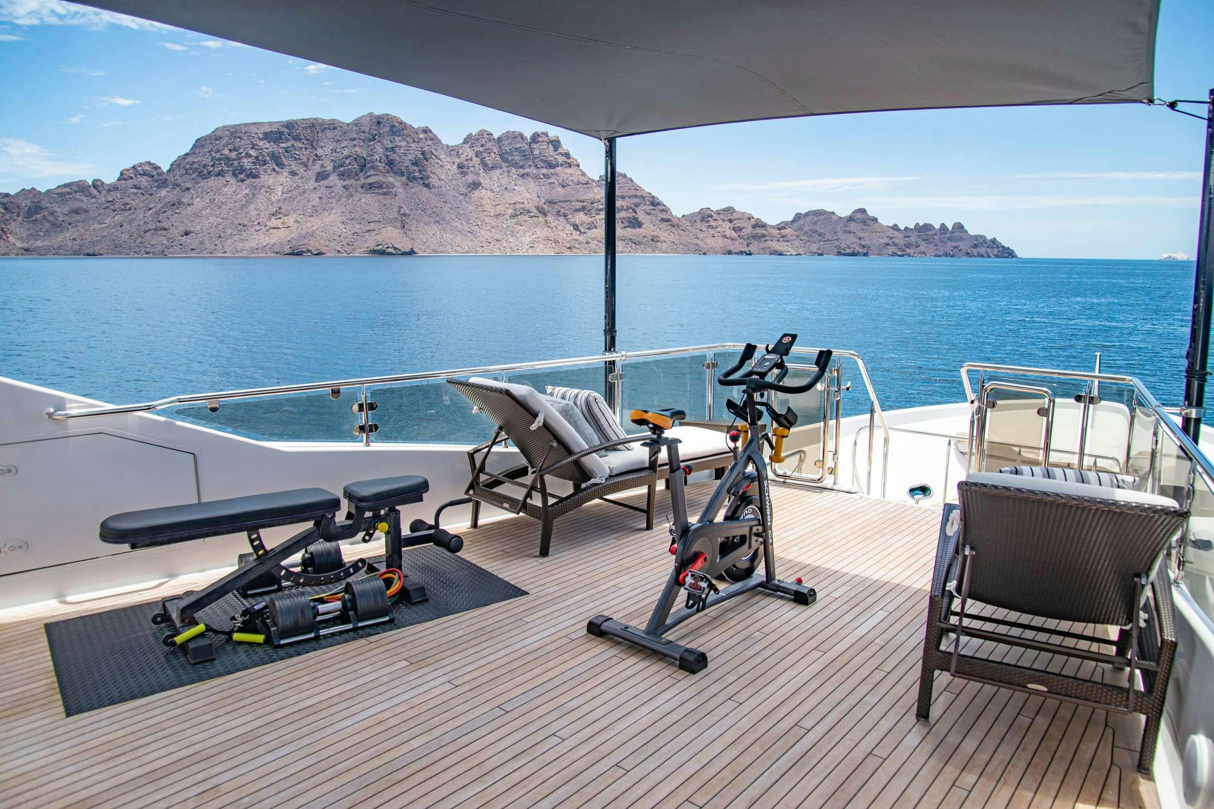 a deck with chairs and a body of water in the background aboard RULE NO. 1 Yacht for Charter