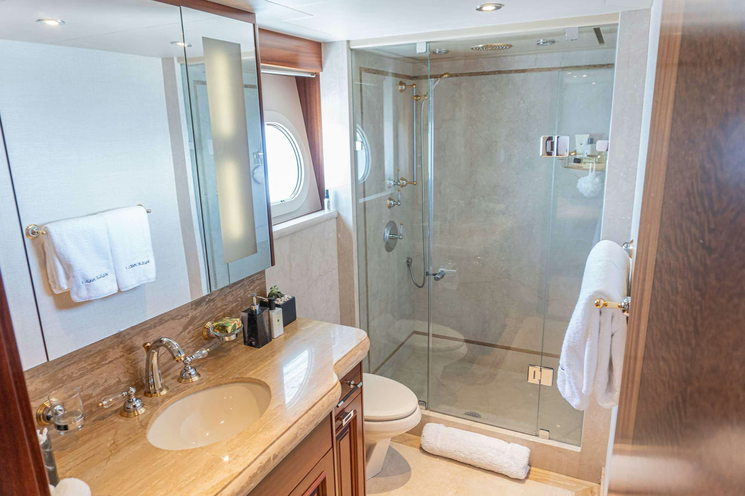 a bathroom with a glass shower door aboard RULE NO. 1 Yacht for Charter