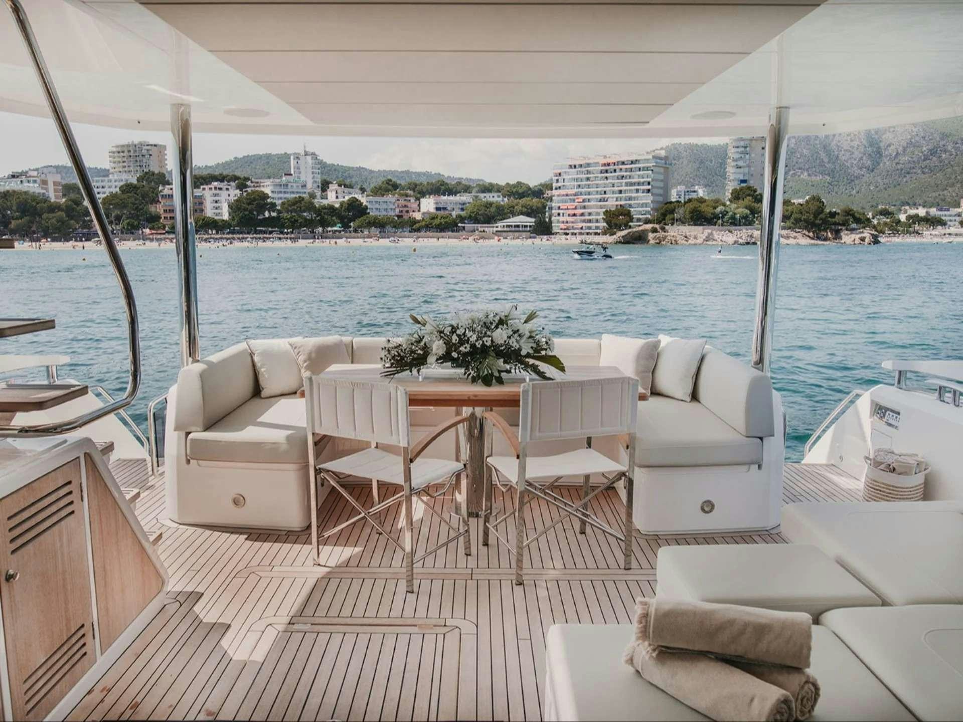 a room with a table chairs and a view of the water aboard LADY M Yacht for Charter