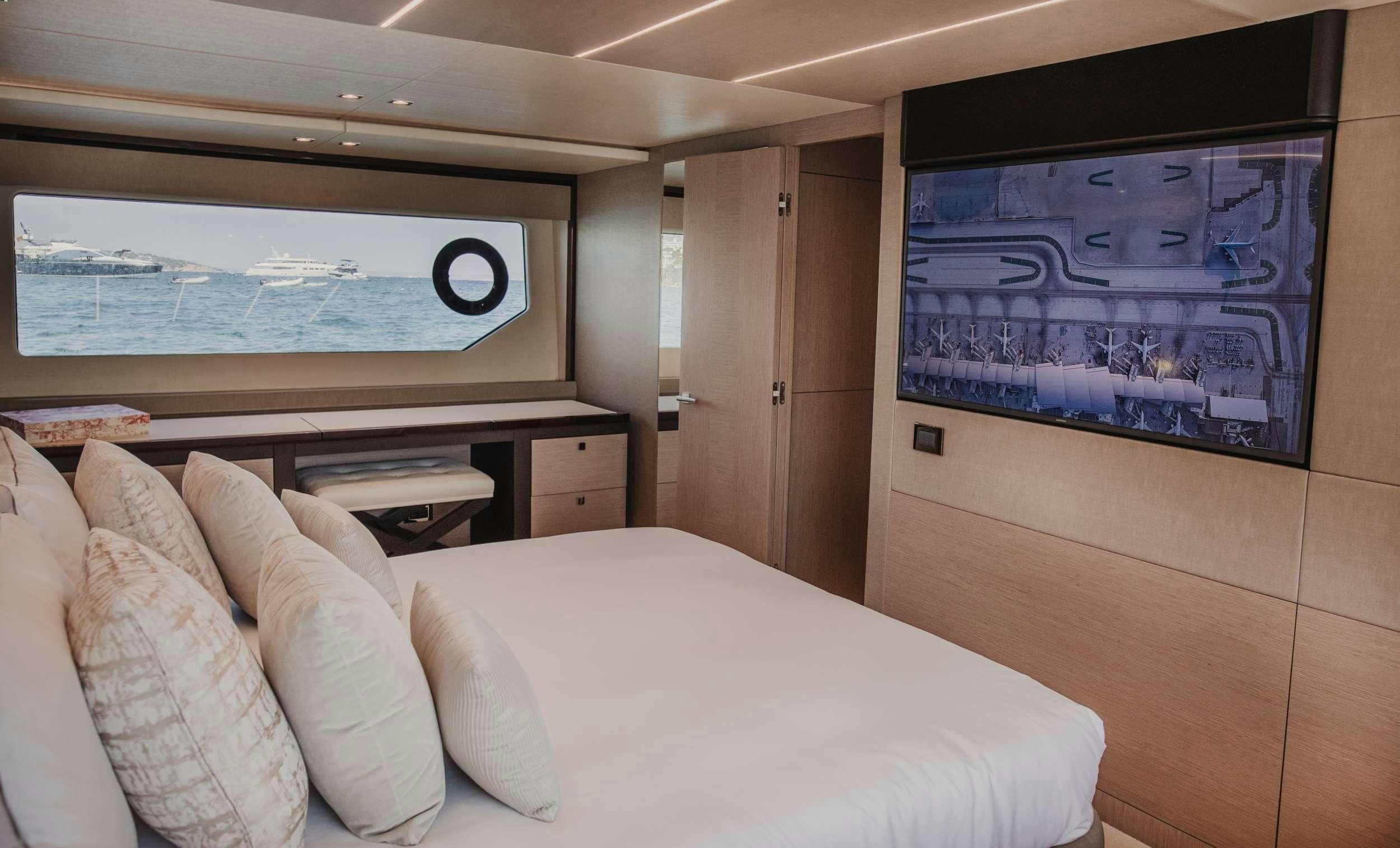 a room with a bed and a tv on the wall aboard LADY M Yacht for Charter