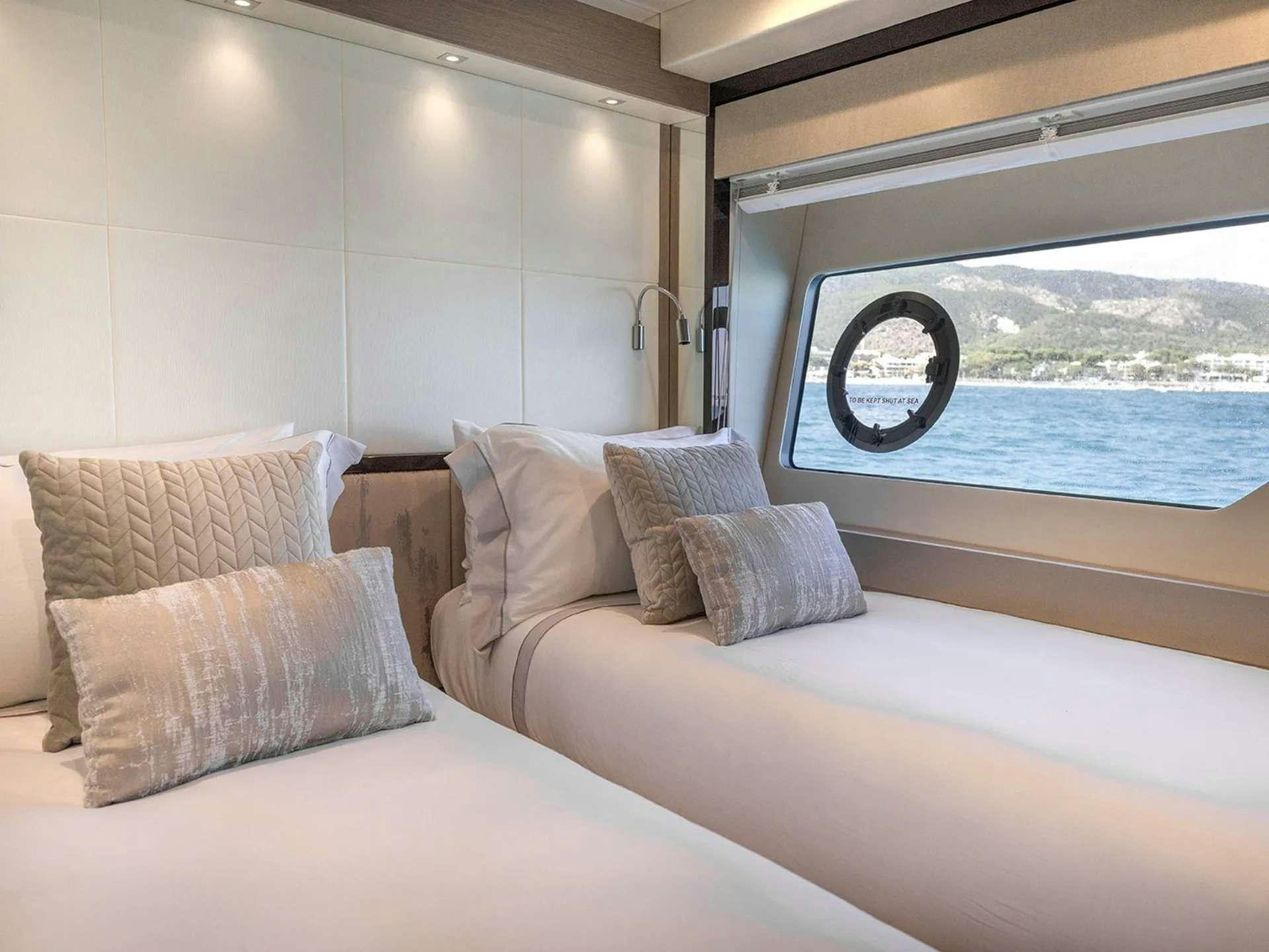a bed with pillows and a window aboard LADY M Yacht for Charter