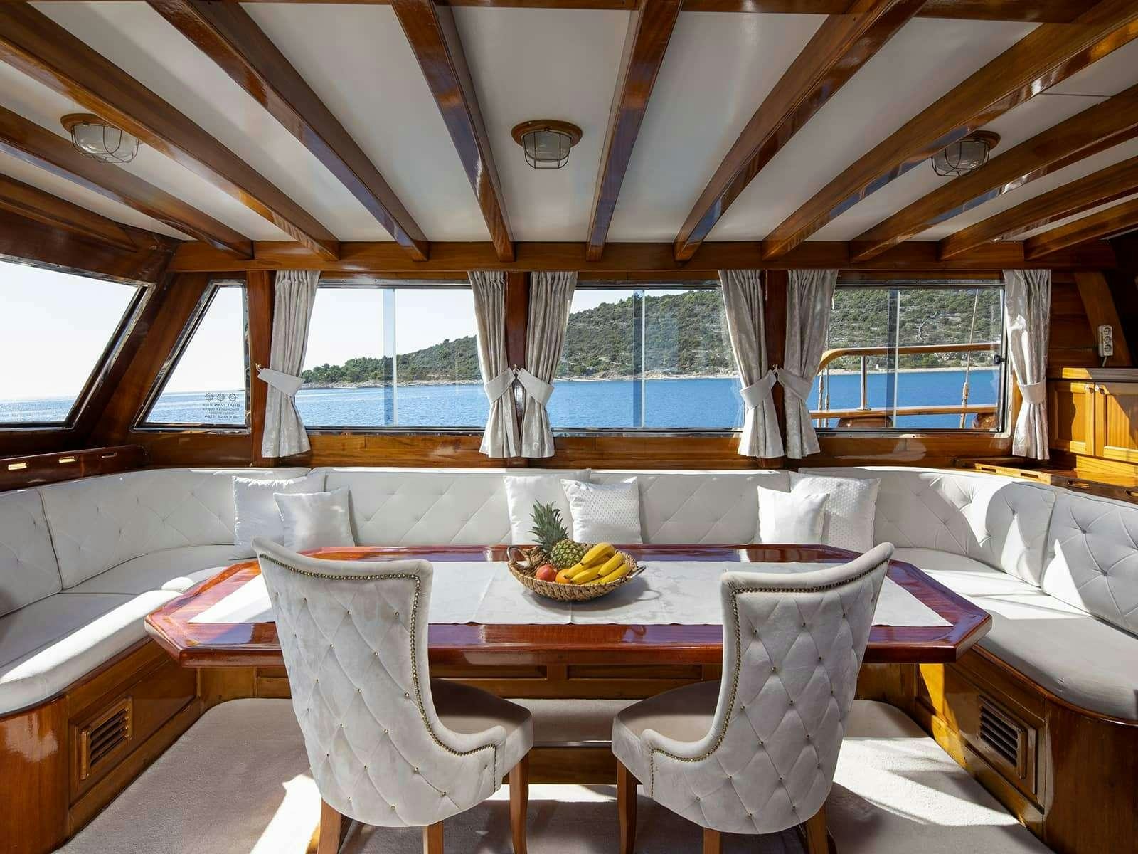 a table with chairs around it aboard GULET ANDI STAR Yacht for Charter