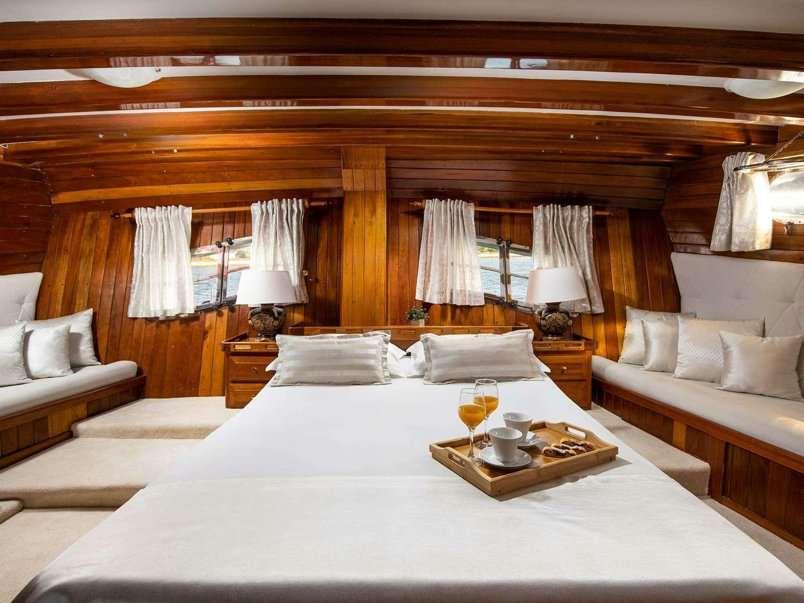 a bed with a white bed spread aboard GULET ANDI STAR Yacht for Charter
