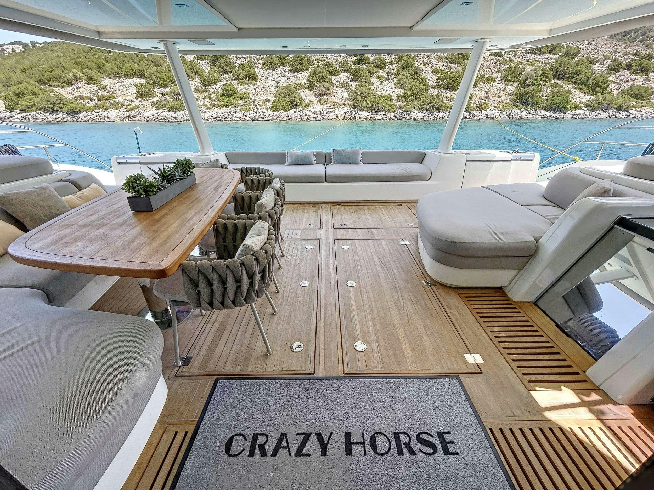 a deck with a table and chairs aboard CRAZY HORSE Yacht for Charter
