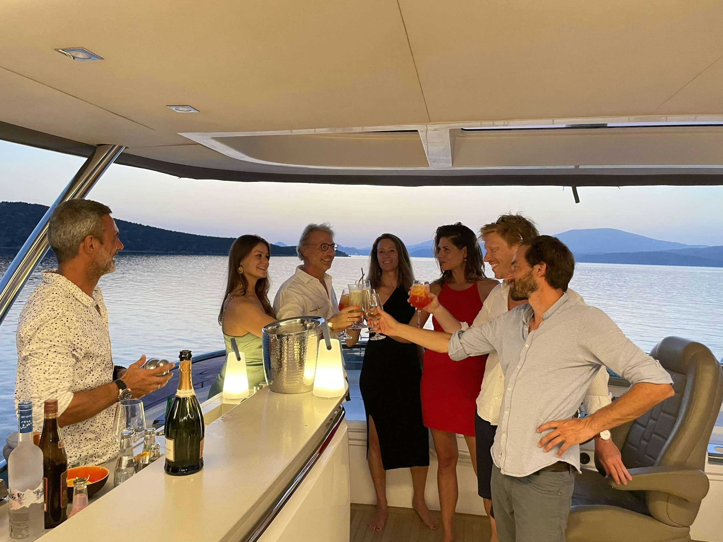 a group of people drinking wine on a balcony aboard CRAZY HORSE Yacht for Charter