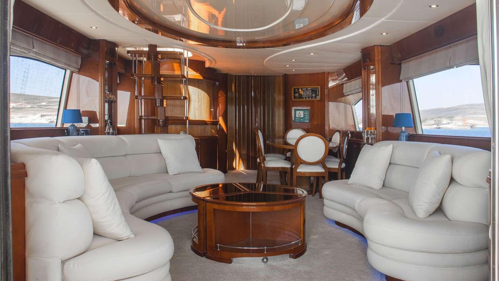 a living room with a large wood table and chairs aboard TITAN Yacht for Charter