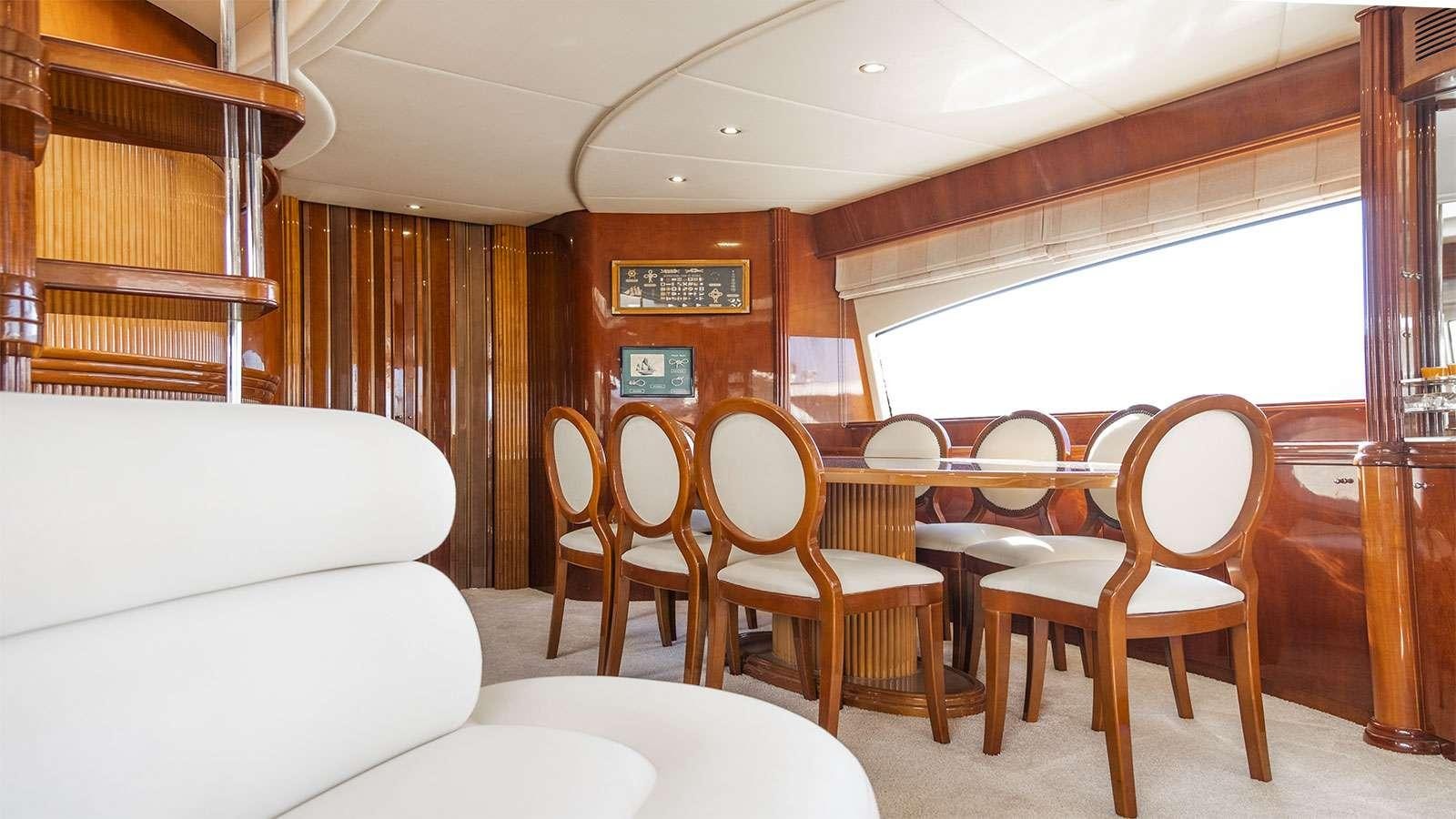 a room with a table chairs and a couch aboard TITAN Yacht for Charter